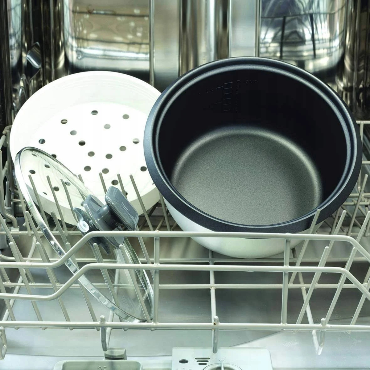 Wnętrze zmywarki z garnkiem wewnętrznym, parowarem i pokrywką z ryżowaru.