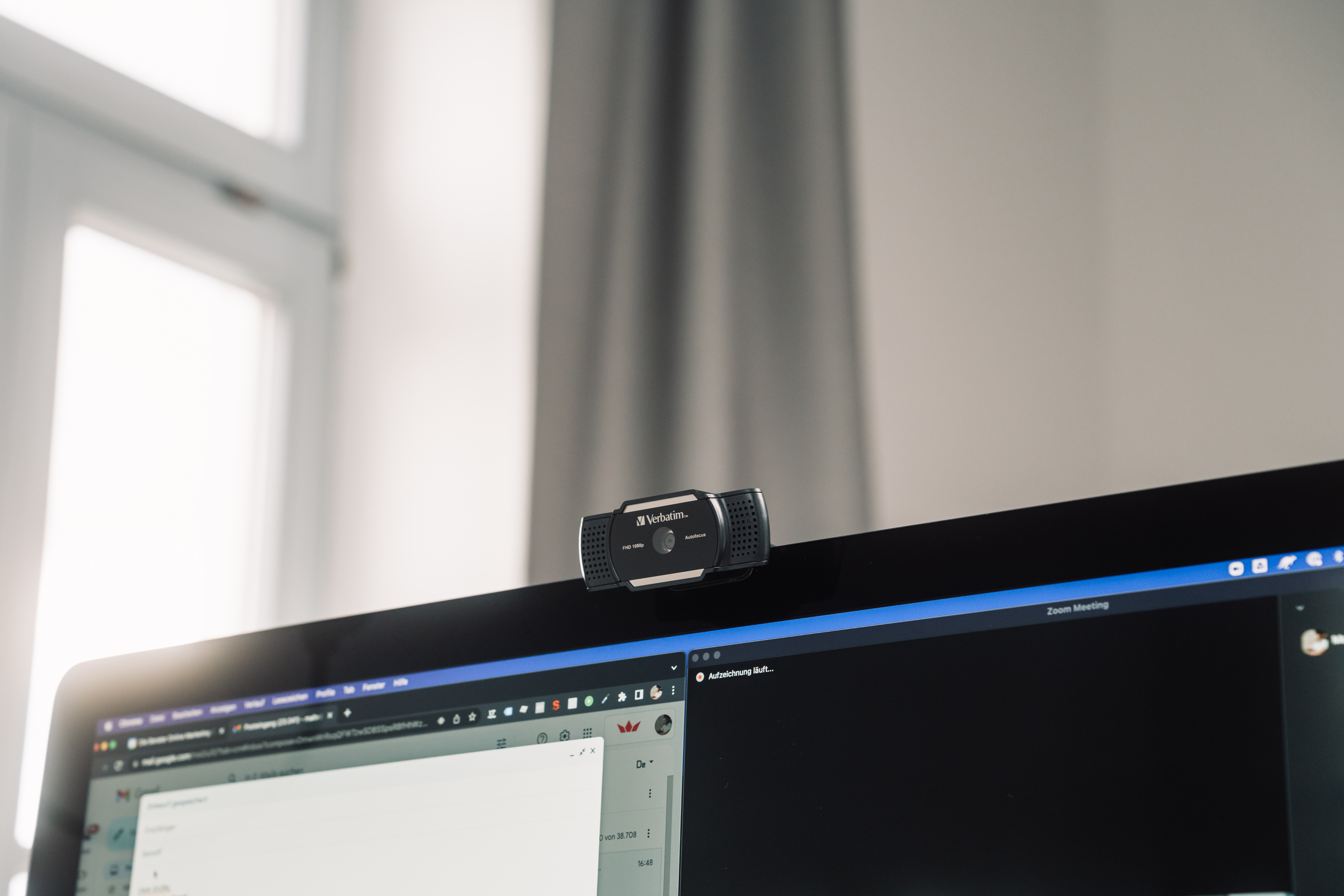 Kamera internetowa na monitorze komputera. Monitor wyświetla interfejs spotkania Zoom.