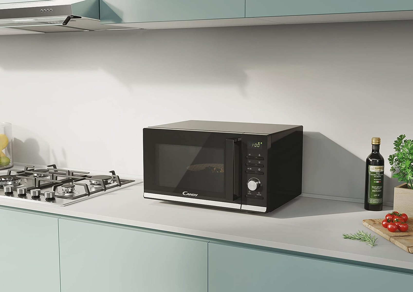 Czarna kuchenka mikrofalowa na blacie kuchennym. Srebrne akcenty, elementy sterujące. Otoczenie kuchni. Biały i niebieski.