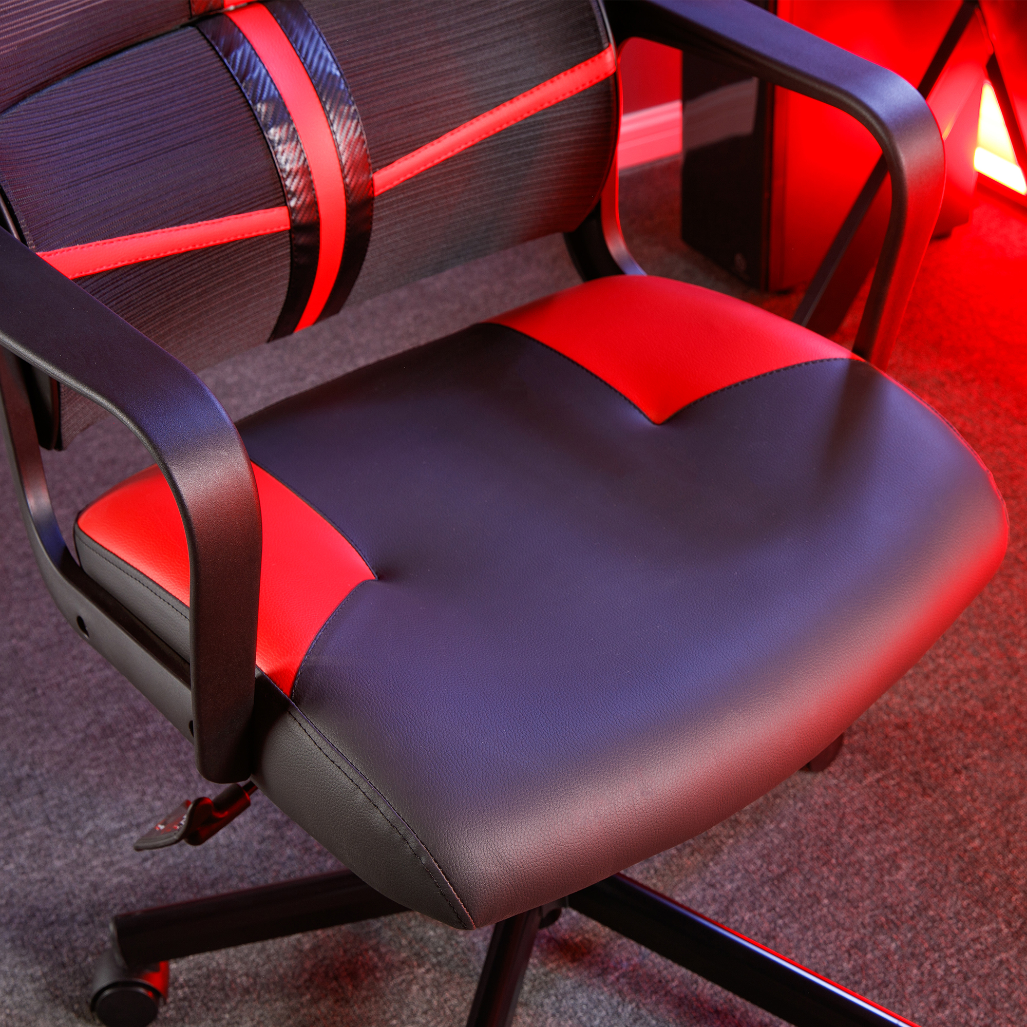 Gaming-Stuhl, schwarz und rot mit rotem herzförmigen Rücken und schwarzen Armlehnen auf grauem Boden.
