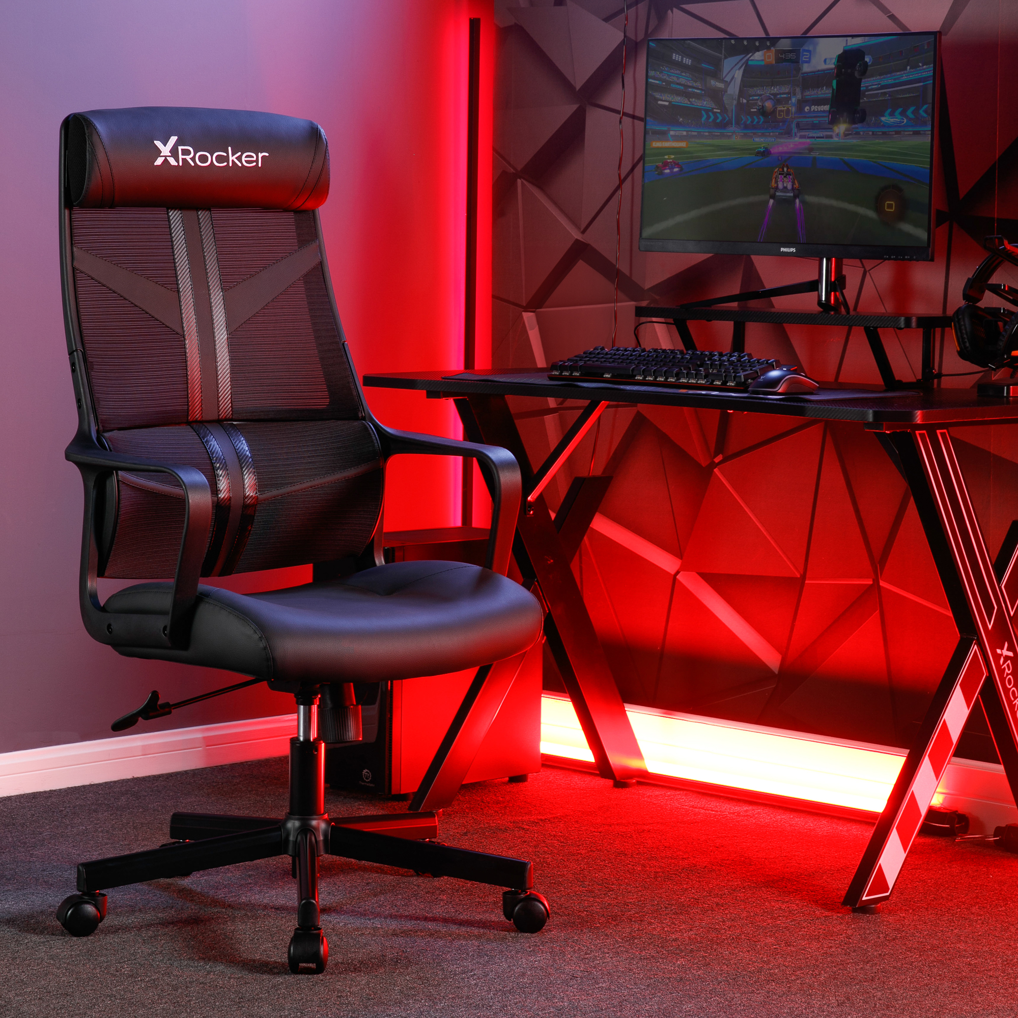 Gaming-Stuhl in einem rot beleuchteten Raum. Schreibtisch mit Monitor.