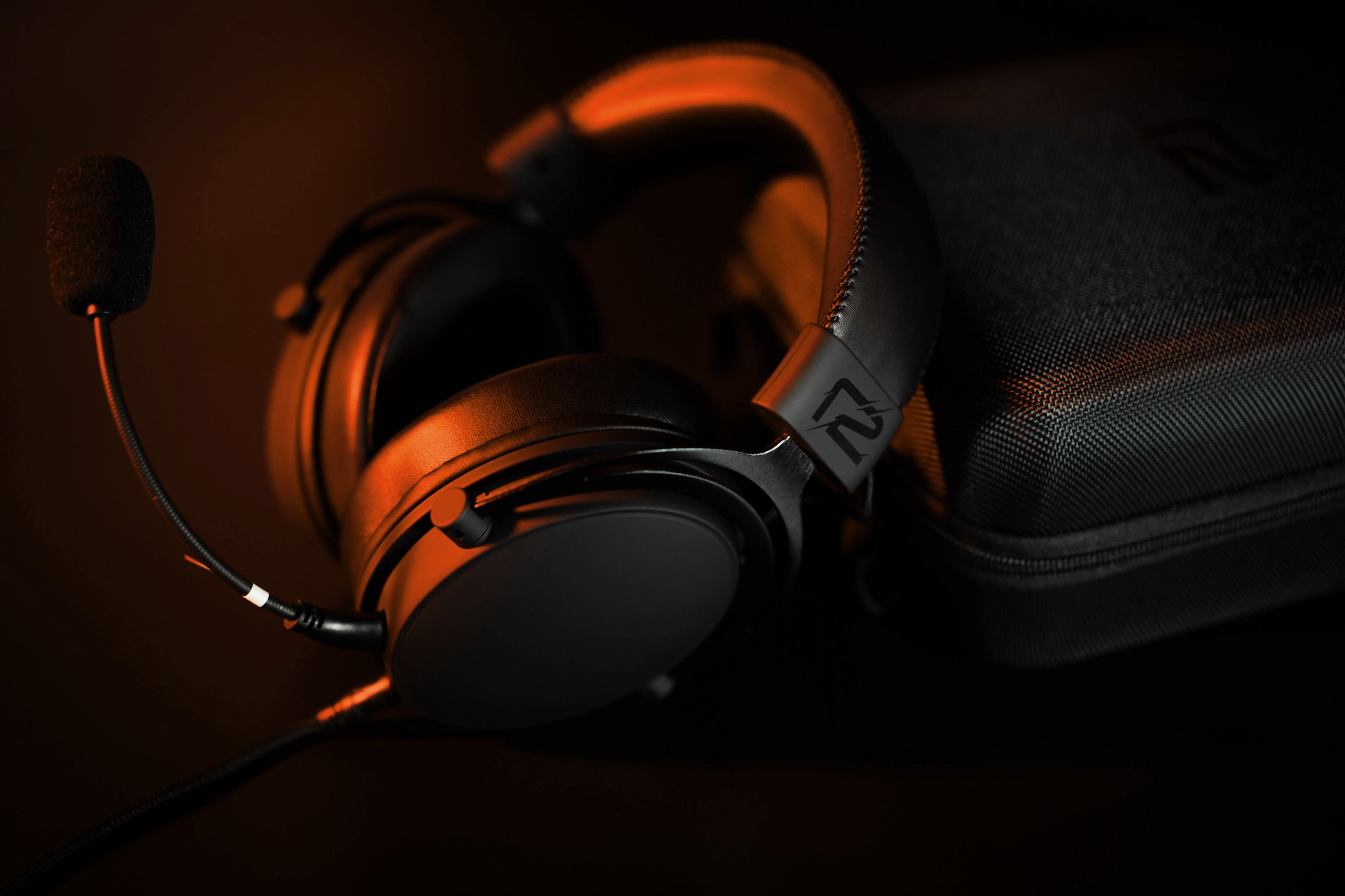 Schwarzes Gaming-Headset mit Mikrofon und Tragetasche. Der Hintergrund ist orange.