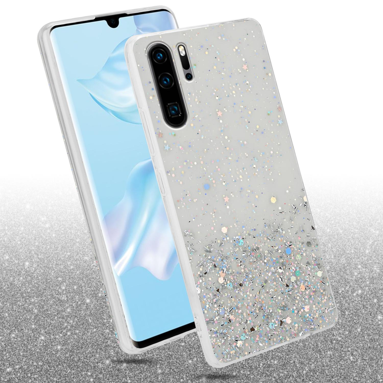 Telefon in Glitzerhülle, anderes Telefon sichtbar, Glitzerhintergrund.