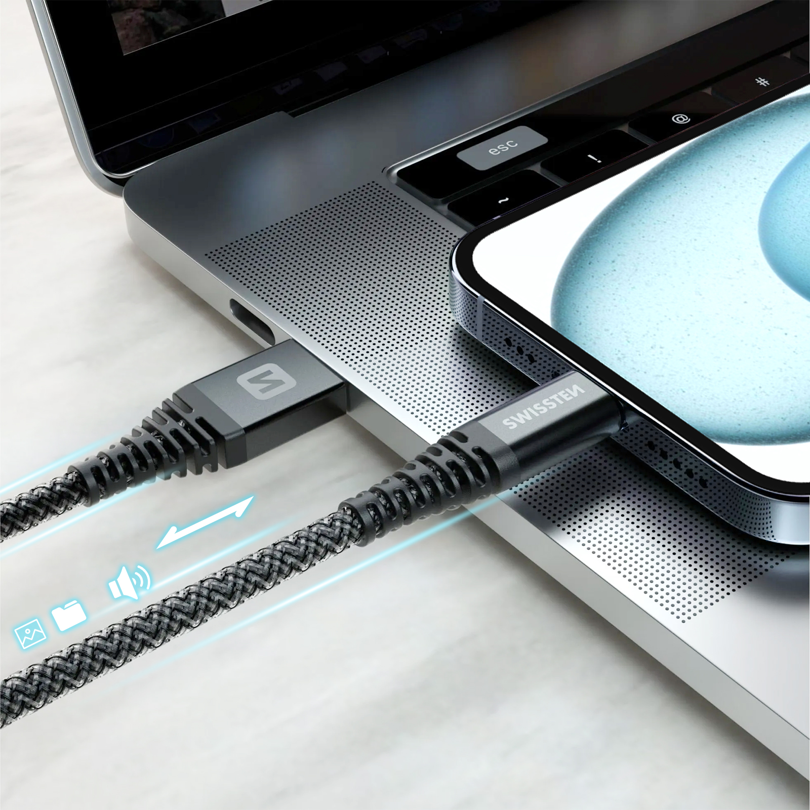 Un telefono è collegato a un laptop con un cavo nero intrecciato. Il cavo ha il logo Swissstem. Sfondo grigio.