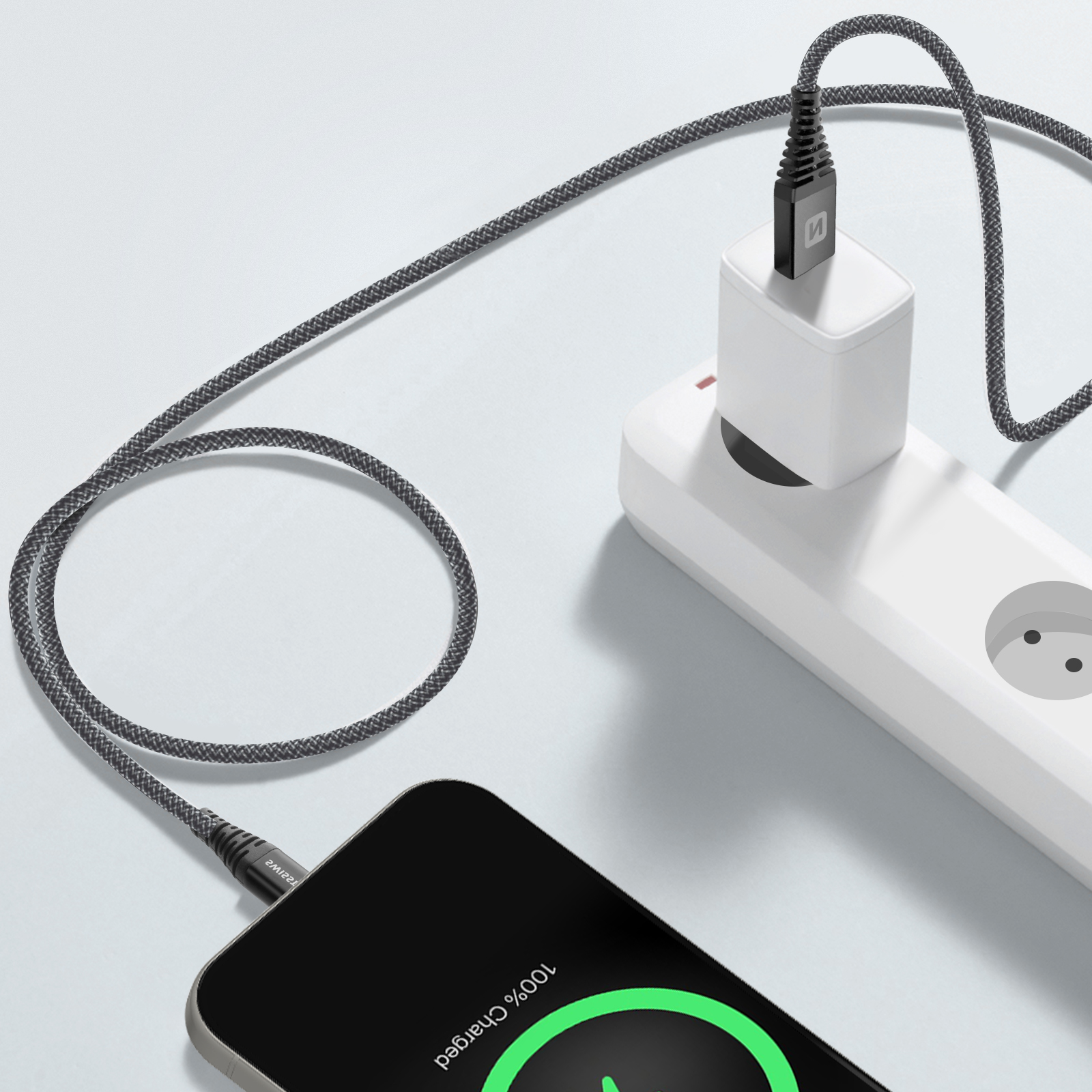 Telefon wird aufgeladen, angeschlossen an eine Steckdosenleiste, mit Kabel am Telefon.