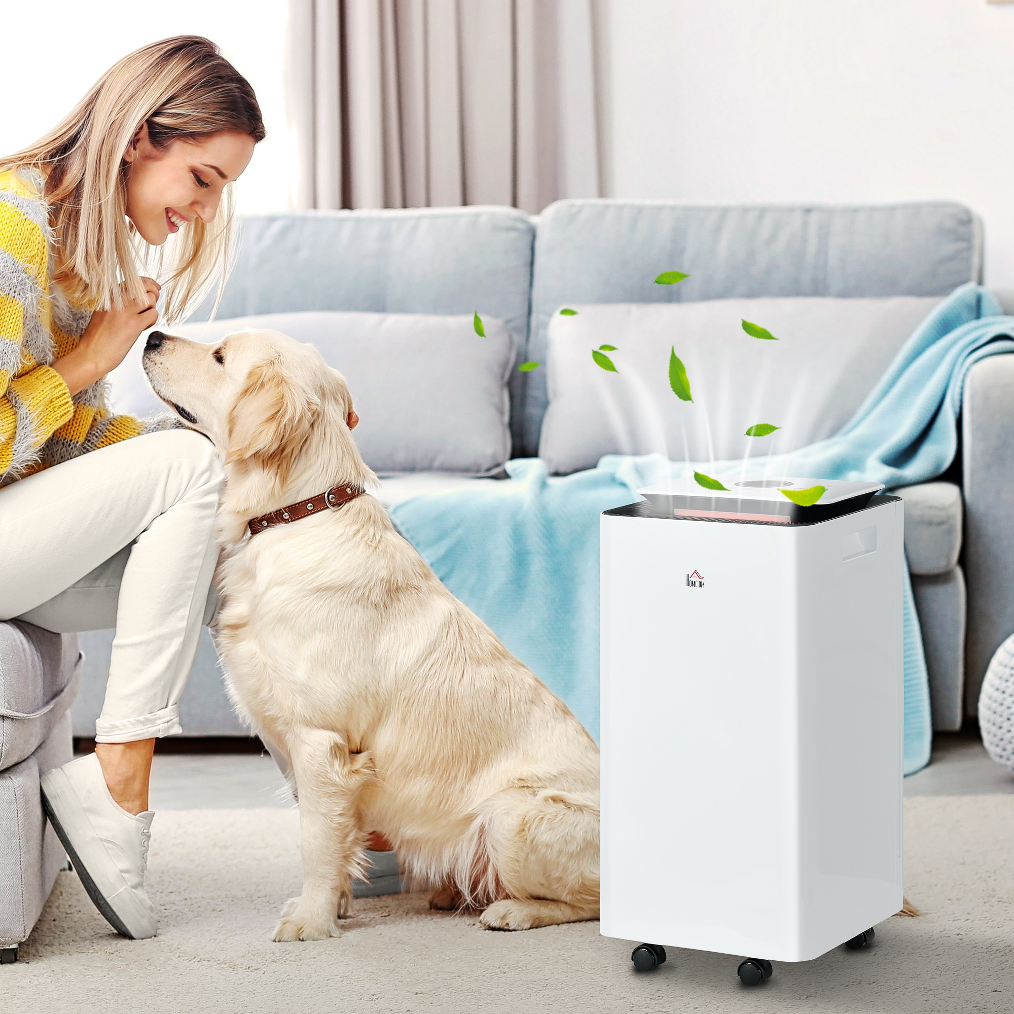 Donna che accarezza un golden retriever vicino a un purificatore d'aria bianco. Le foglie provengono dall'alto.
