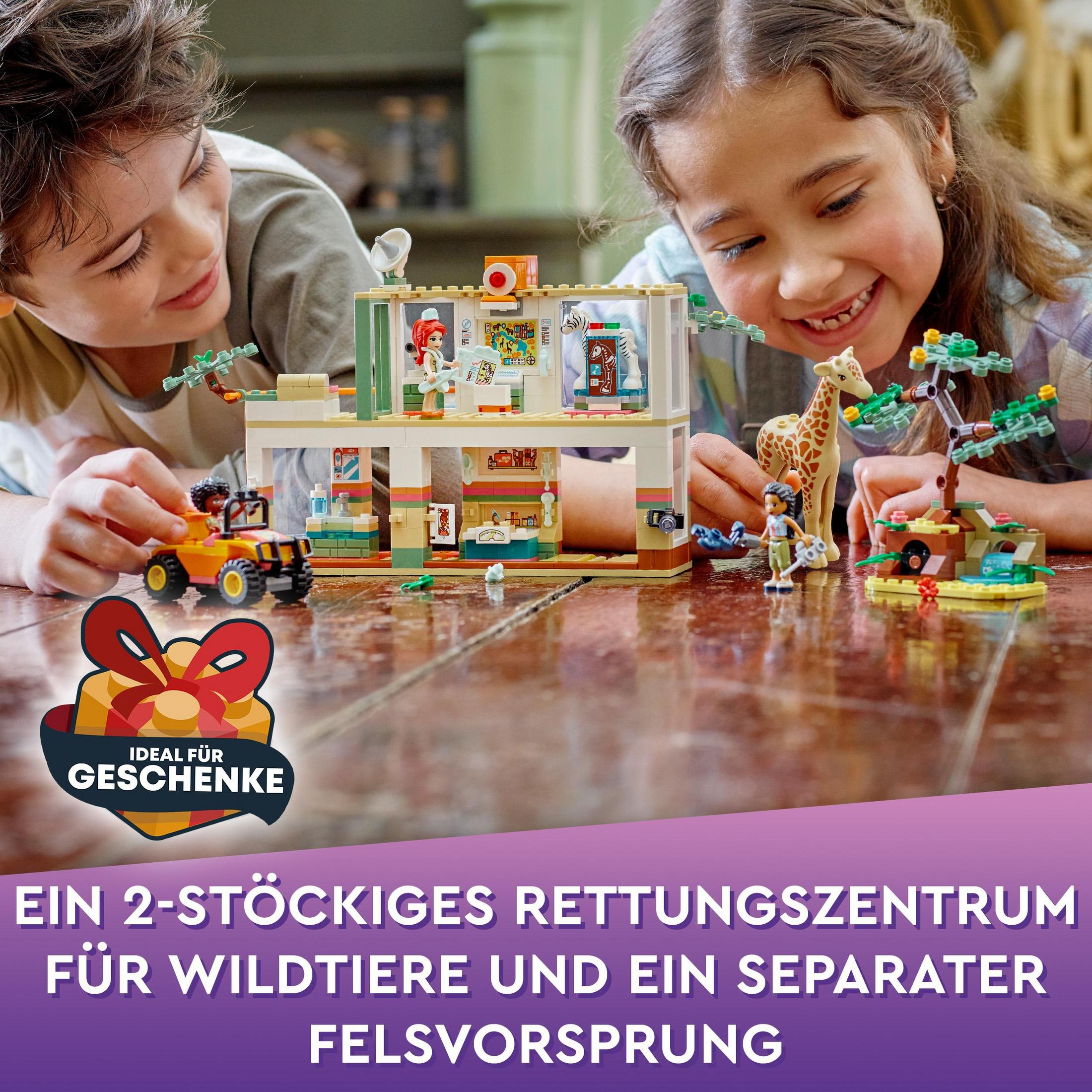 Kinder spielen mit einem Lego-Set. Eine Giraffe und ein Rettungszentrum sind sichtbar.