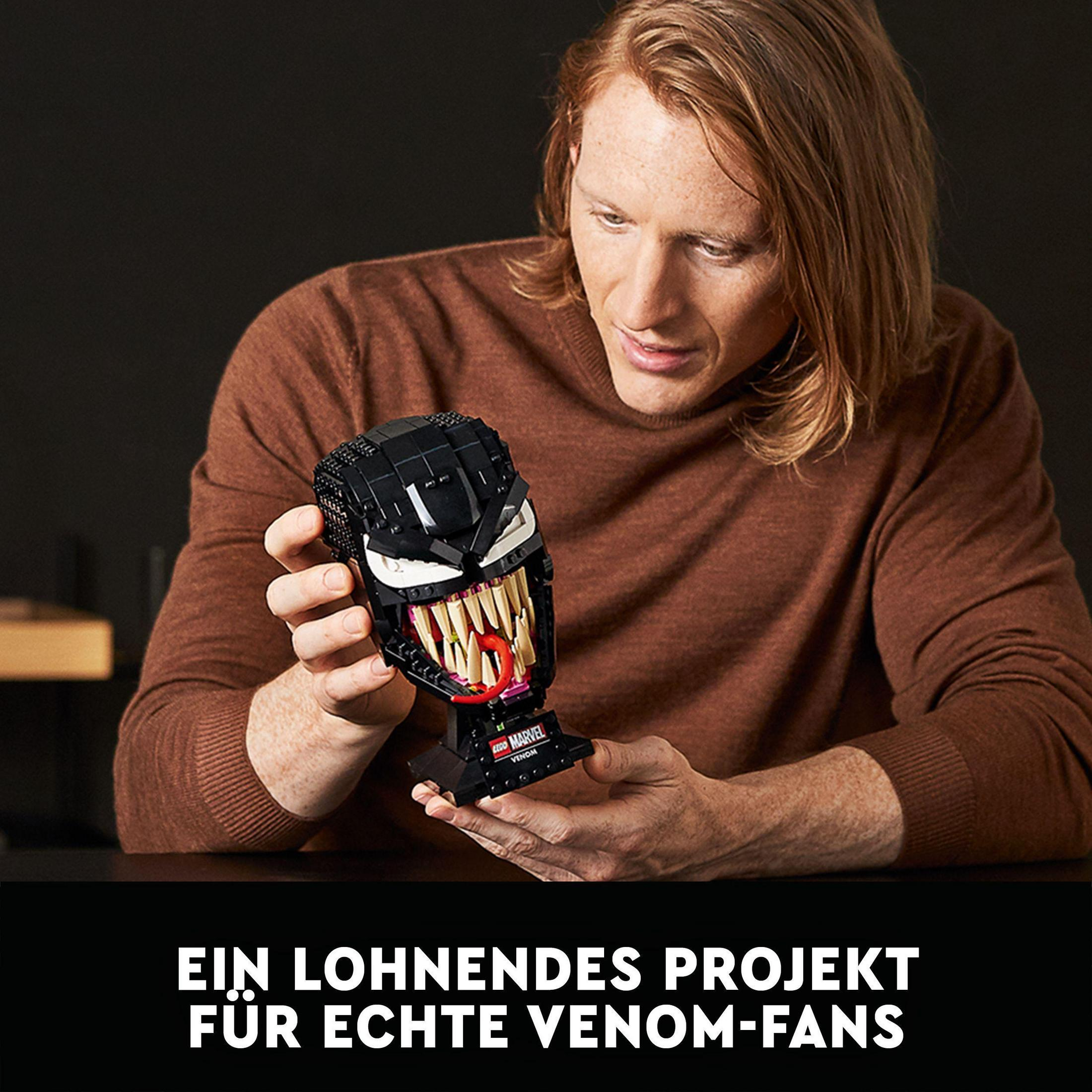 Mężczyzna trzymający głowę Lego Venom. Tekst: Satysfakcjonujący projekt dla prawdziwych fanów Venoma.