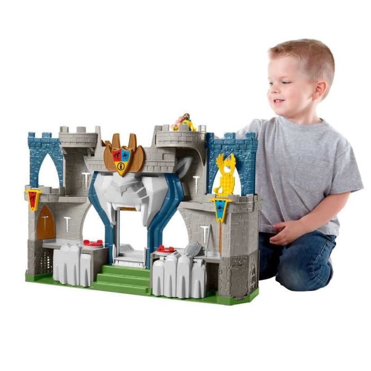 Ein Junge spielt mit einer Spielzeugburg. Die Burg ist grau und blau, mit einer grünen Basis.