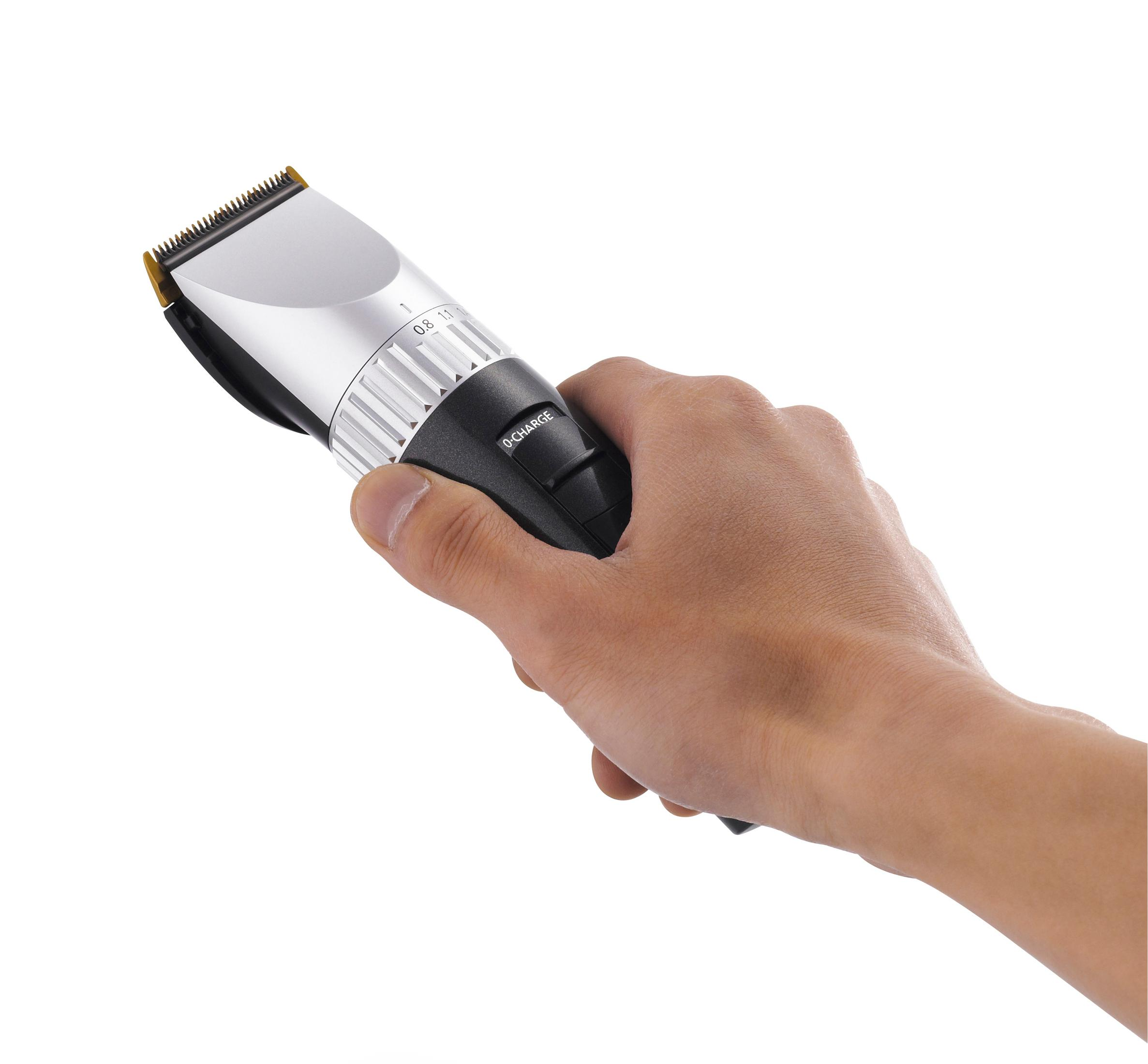 Eine Hand hält einen silbernen und schwarzen Haarschneider. Die Klinge befindet sich oben, ein Einstellrad für die Länge ist sichtbar.