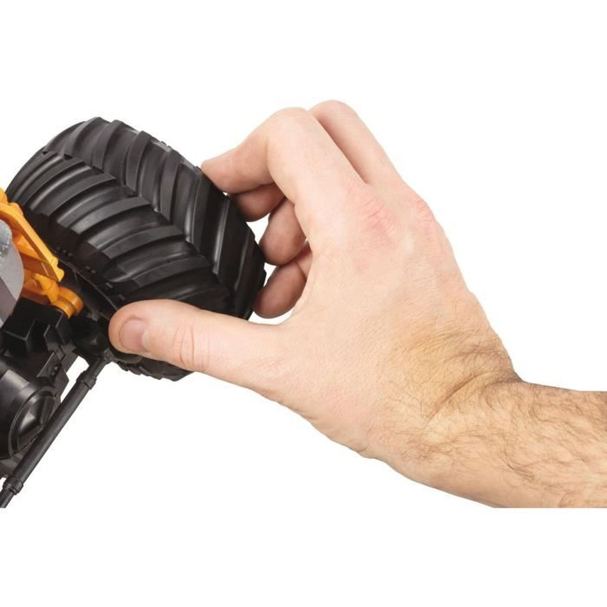 Die Hand einer Person, die einen schwarzen Reifen an einem Spielzeug-LKW hält.