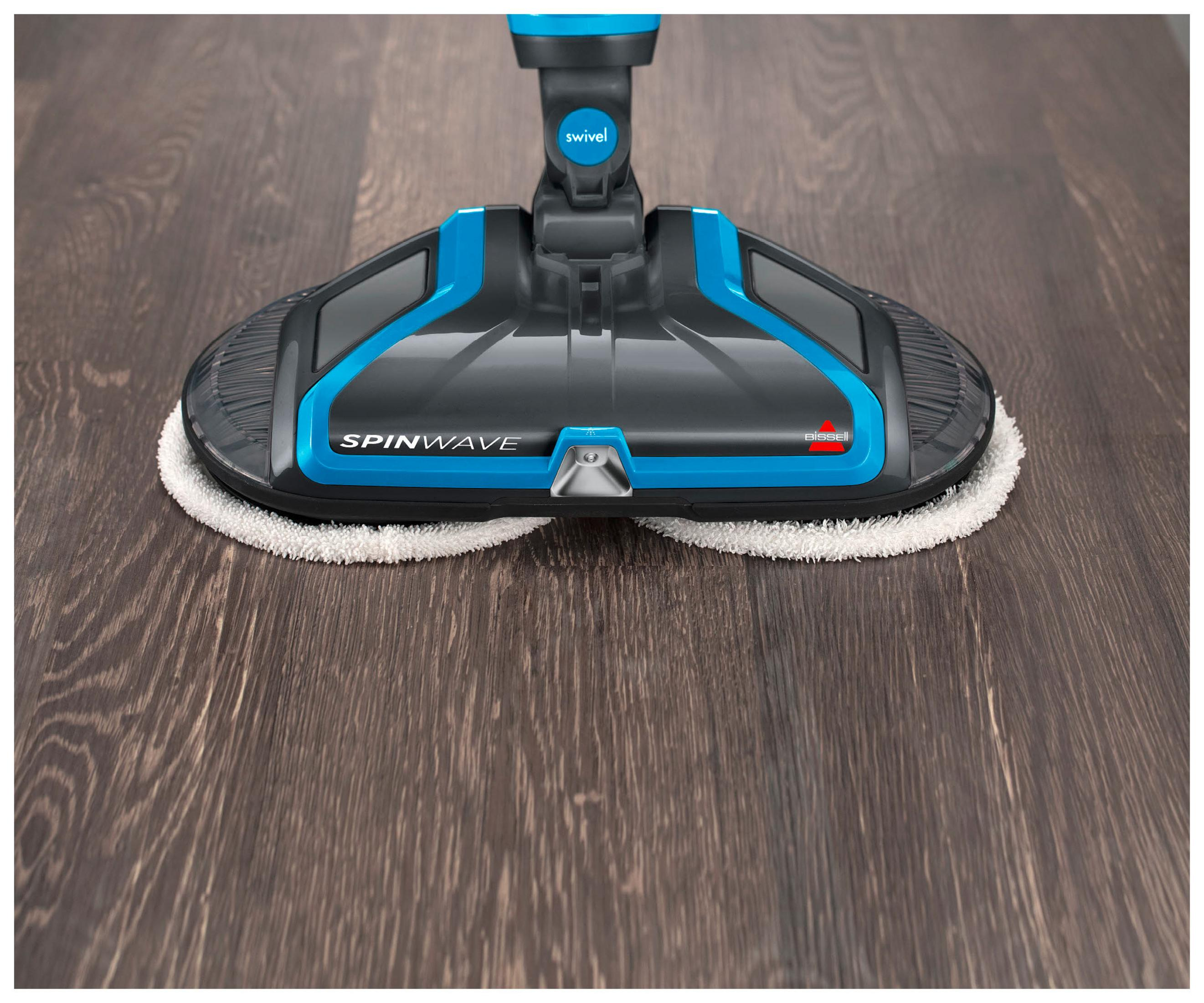 SpinWave Bodenreiniger reinigt dunklen Holzboden. Weiße Pads, schwarzer und blauer Reiniger.