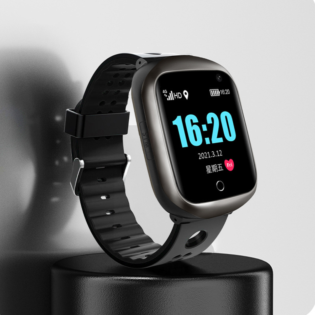 Czarny smartwatch wyświetlający godzinę i datę. Spoczywa na czarnym stojaku.