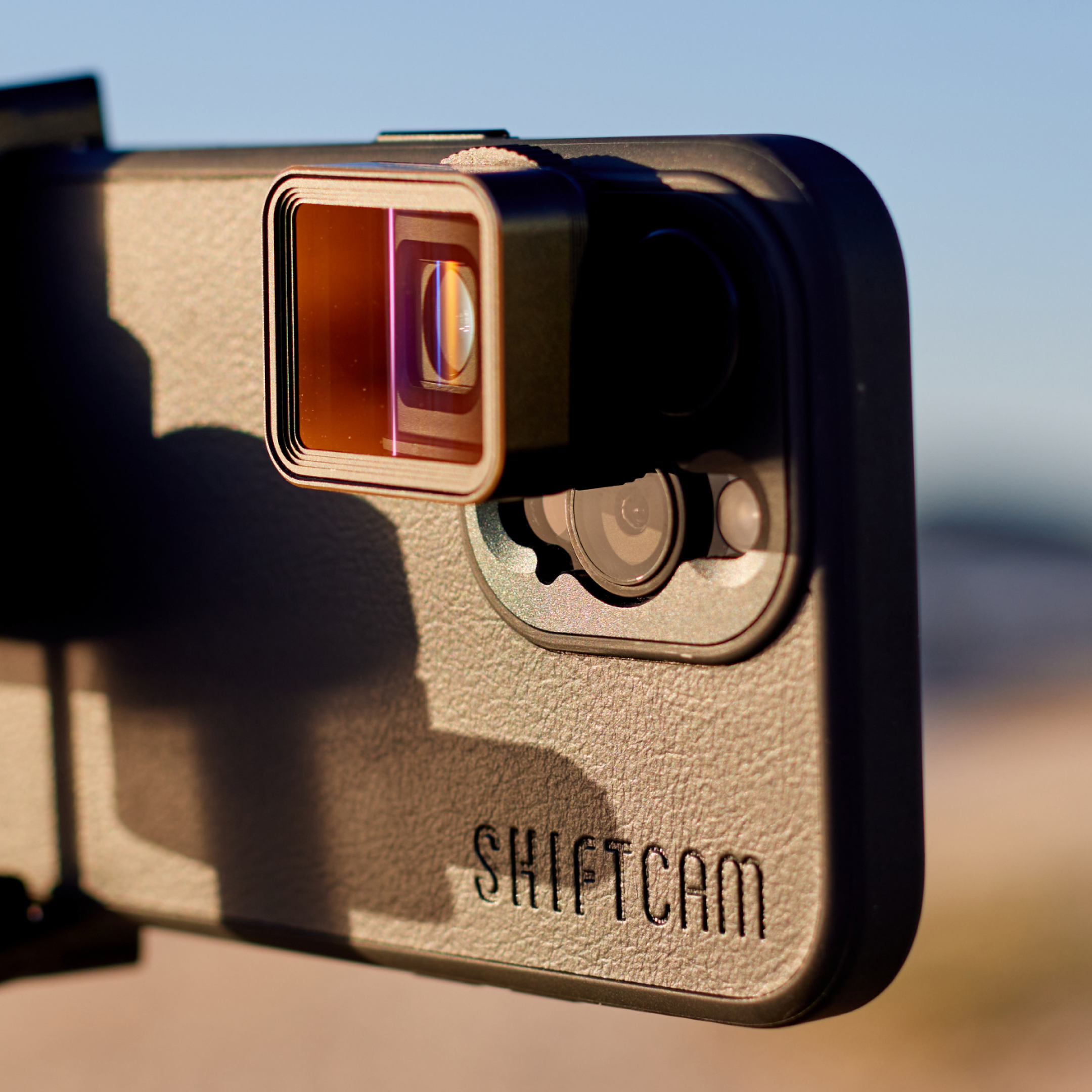 Nahaufnahme einer Kameralinse an einem Telefon, mit 'SHIFTCAM' auf dem Gehäuse.
