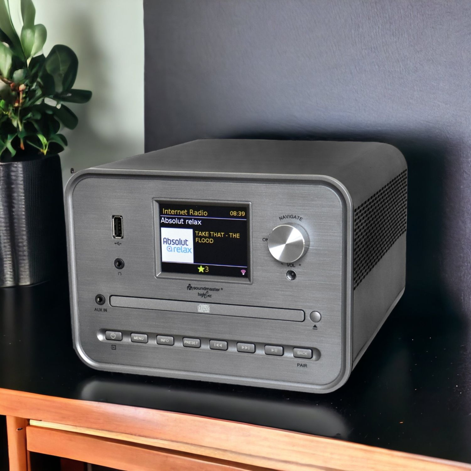 Ein silbernes Soundmaster-Radio mit einem Display, das den Radiosender und die Uhrzeit anzeigt.