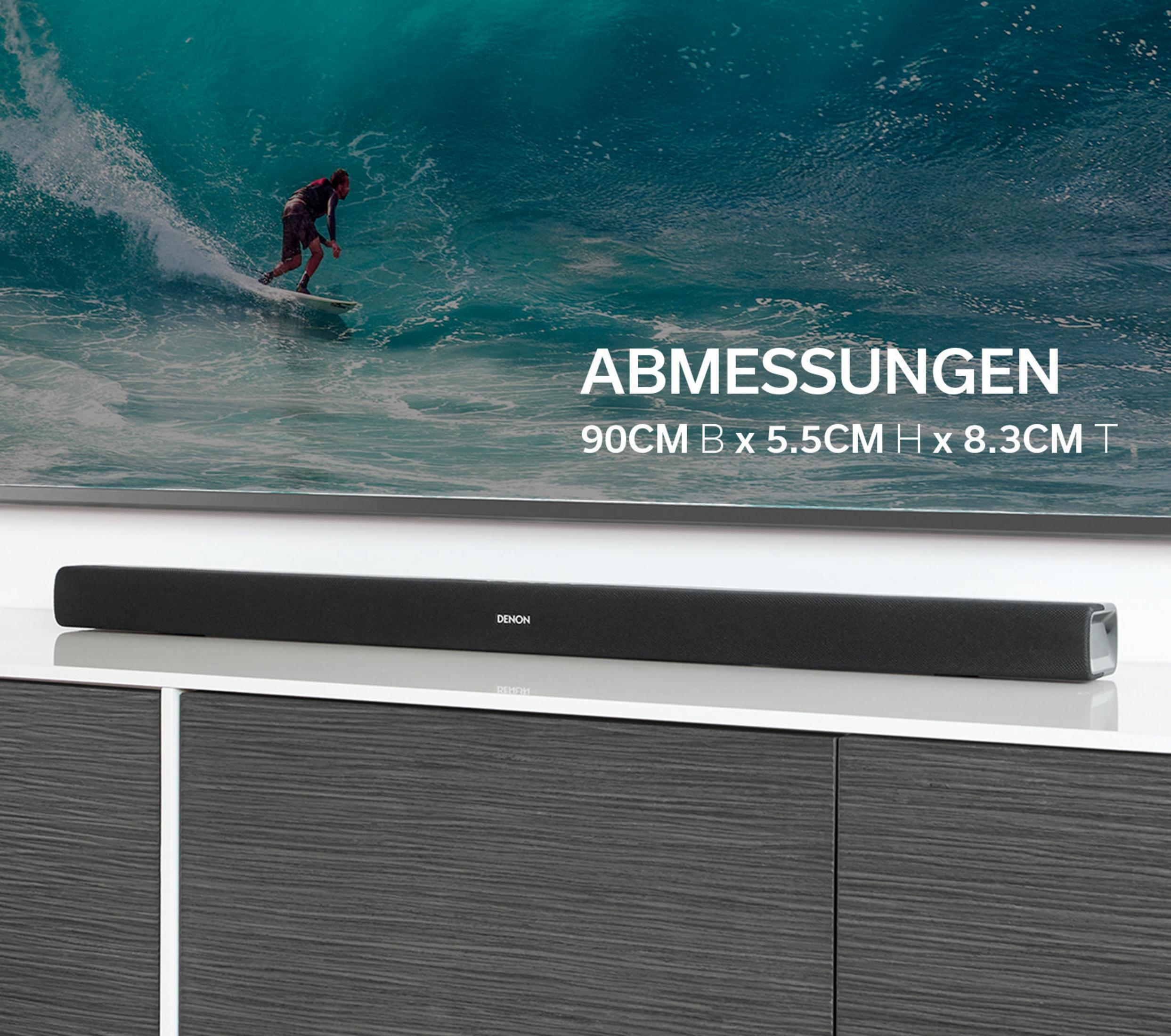 Eine schwarze Soundbar auf einem Schrank. Über der Soundbar befindet sich ein Fernseher mit einem Surfer auf dem Bildschirm.