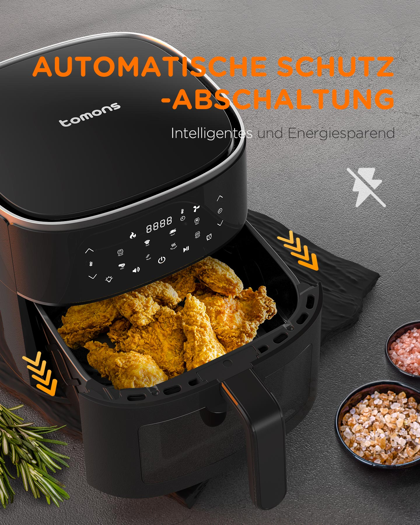 Eine schwarze Heißluftfritteuse mit einem Korb voller gebratenem Huhn und Gewürzschalen.