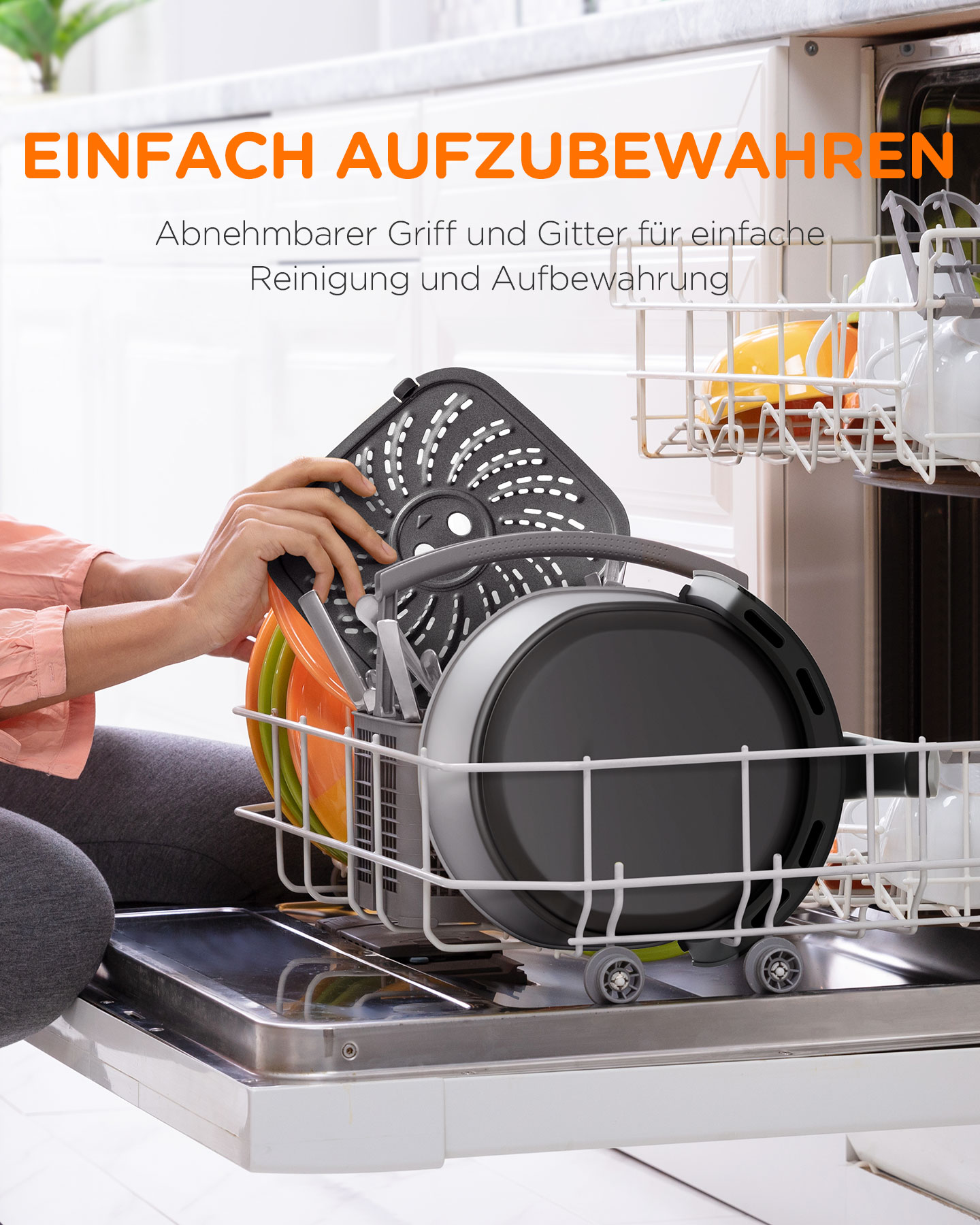 Frau mit Heißluftfritteuse, reinigt das Gerät und legt Teile in die Spülmaschine.