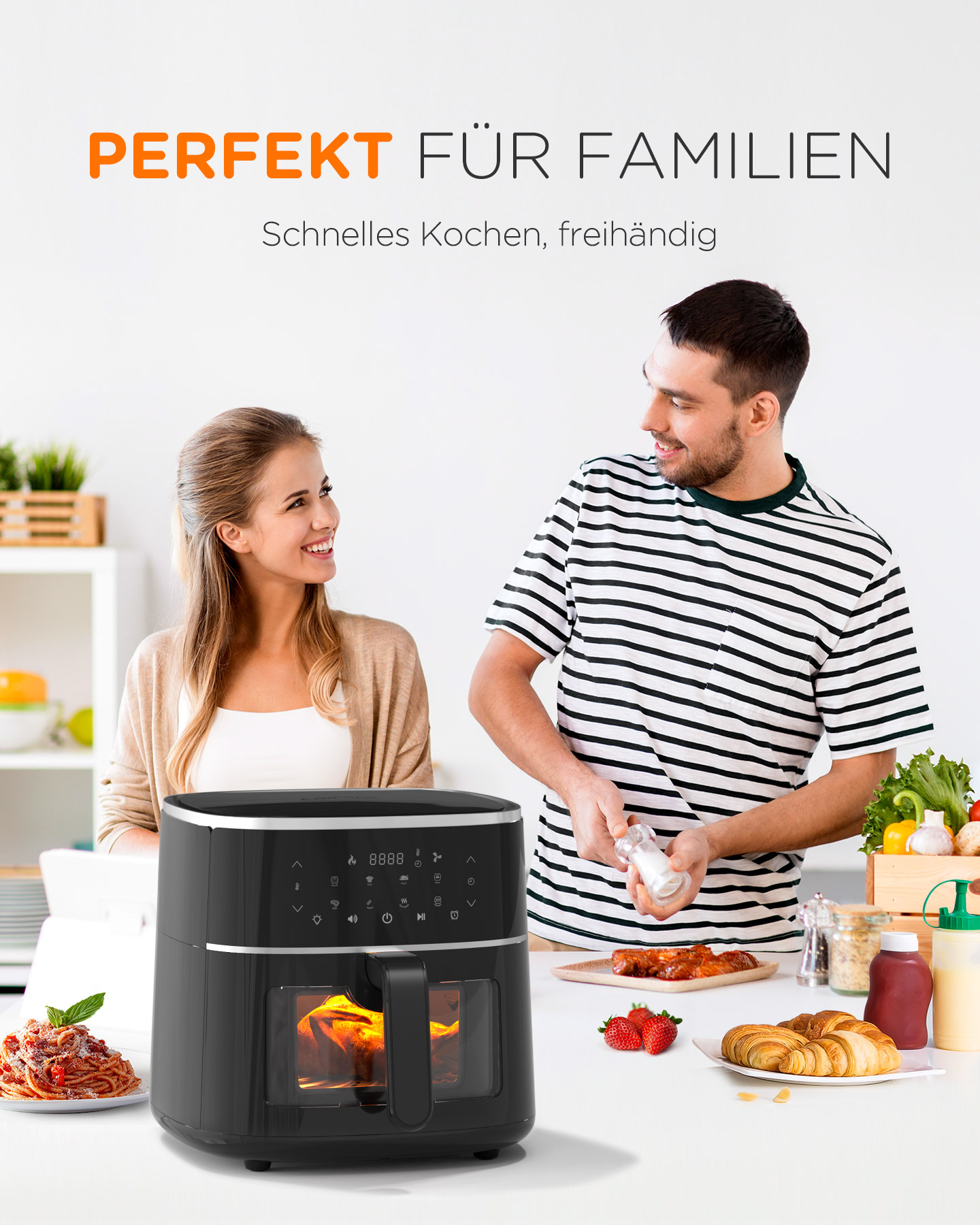 Ein Paar kocht mit einer Heißluftfritteuse. Der Mann gibt Salz hinzu. Essen und Zutaten auf dem Tisch.