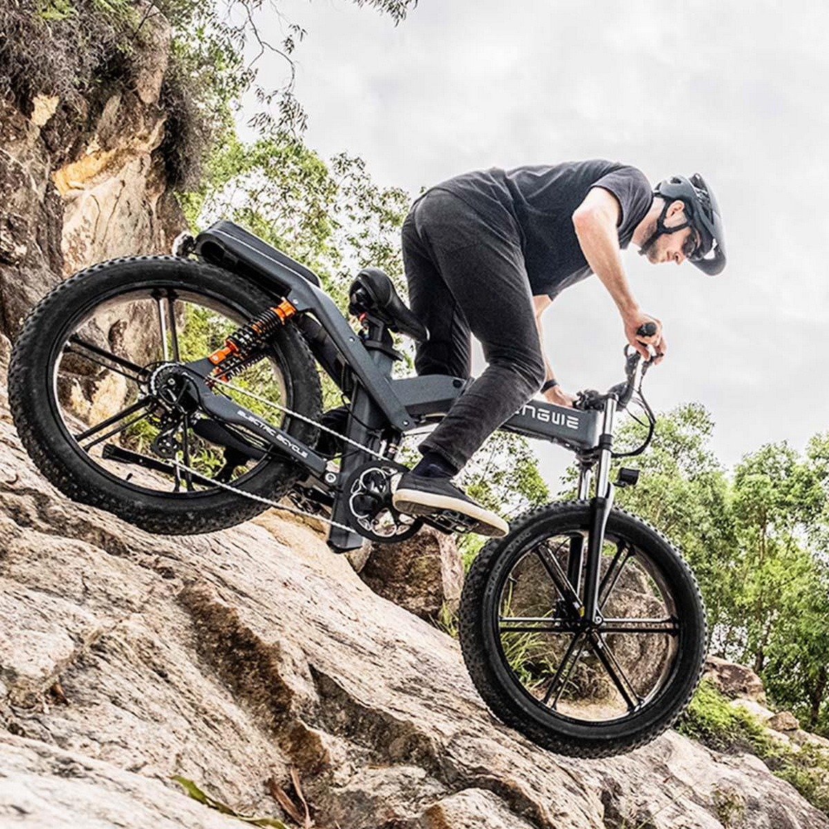 Ein Mann fährt mit einem elektrischen Mountainbike auf felsigem Gelände, trägt Helm.