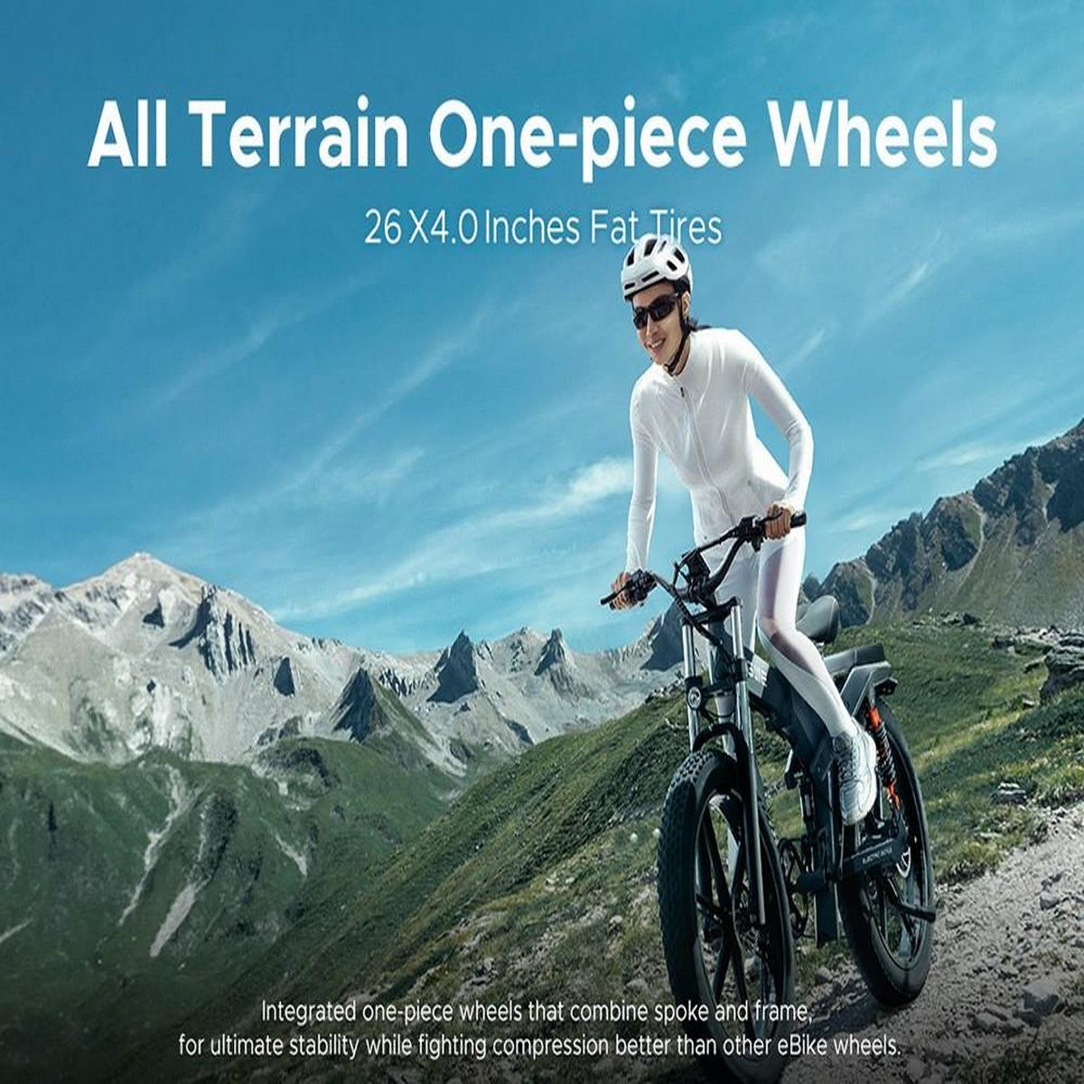 Frau fährt mit einem schwarzen E-Bike auf einem Bergpfad. Berglandschaft im Hintergrund.