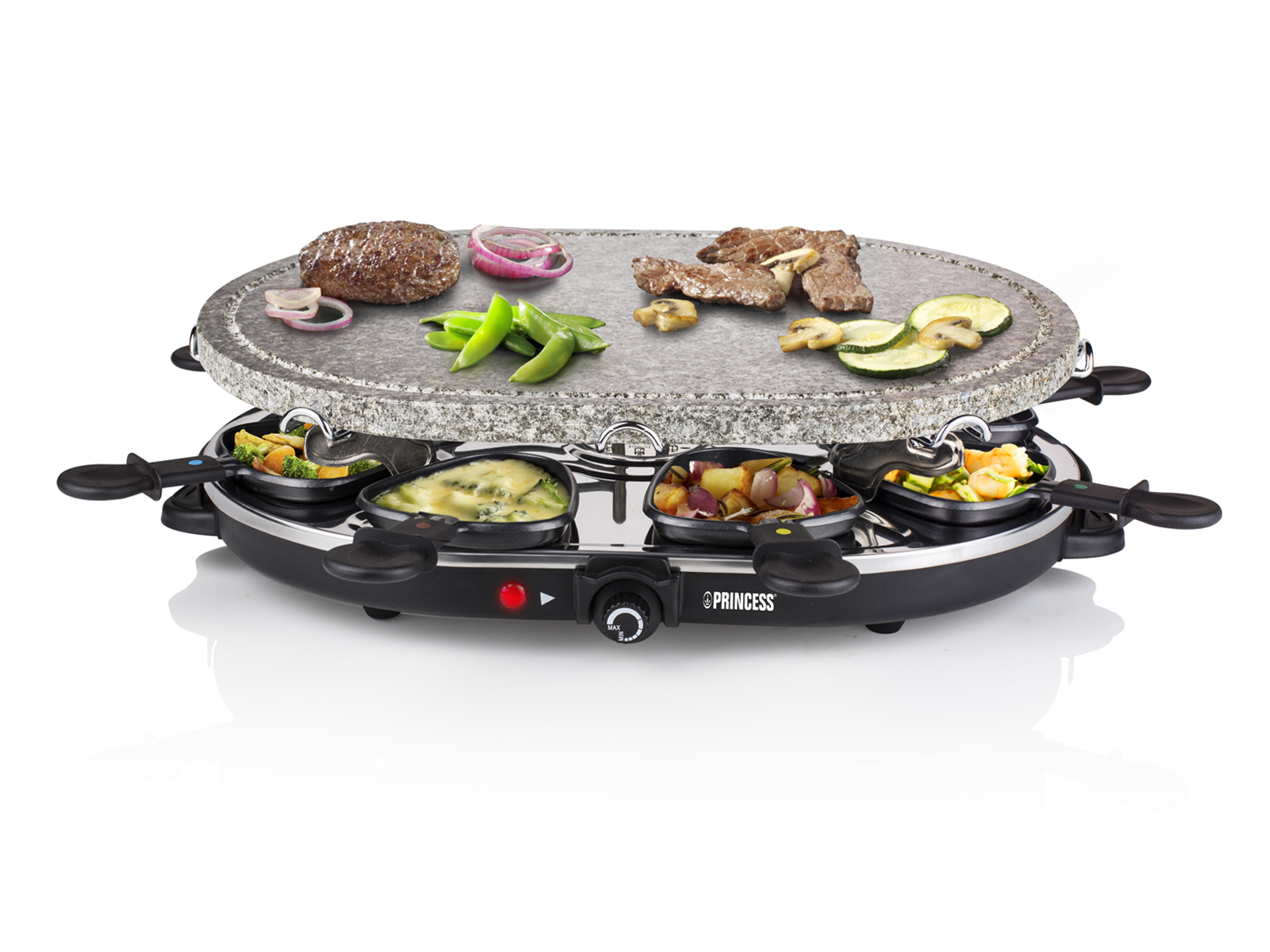 Ein Raclette-Grill mit Essen, einschließlich Gemüse und Fleisch. Der Grill steht auf weißem Grund.