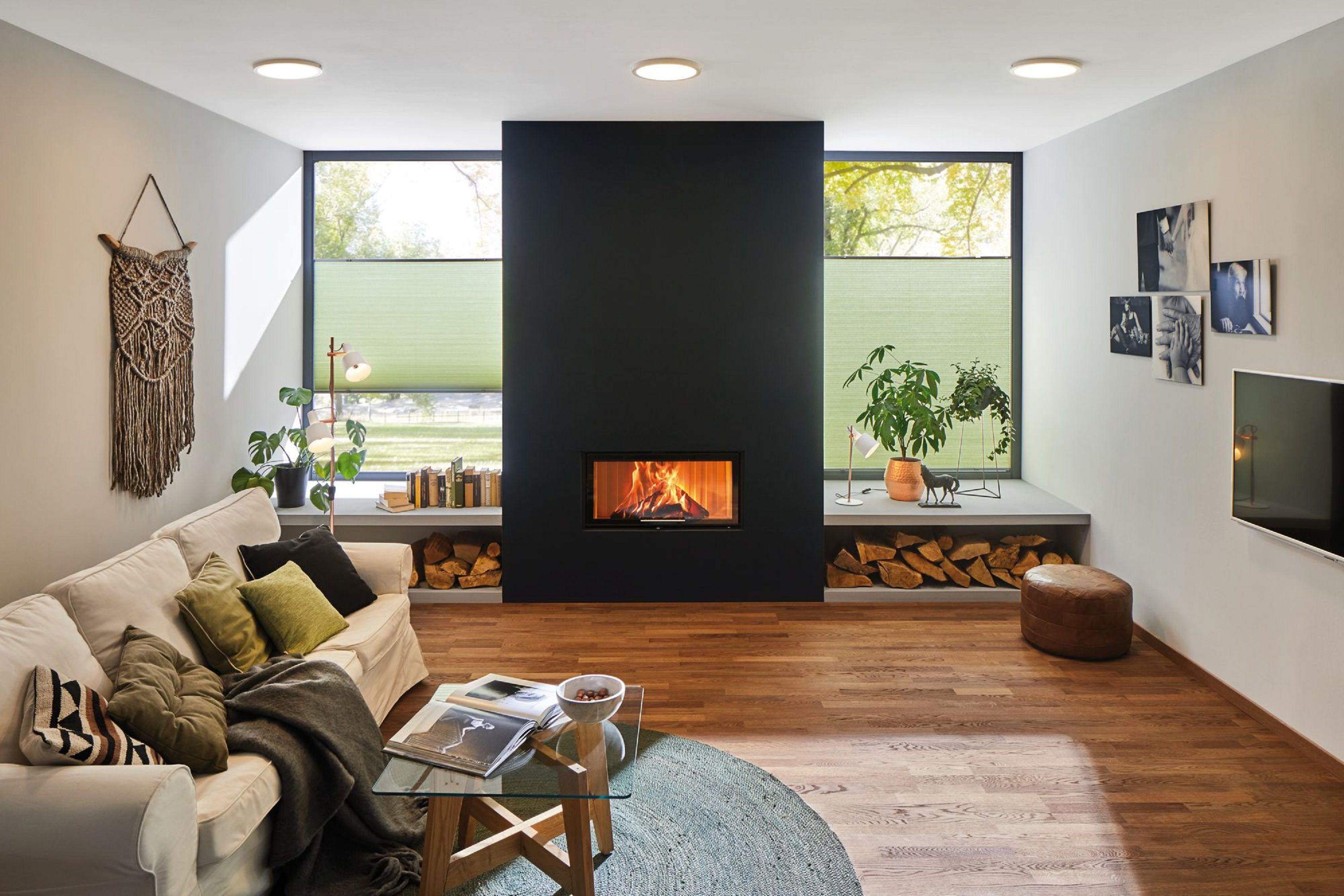 Salon z kominkiem, sofą i oknami, prezentujący nowoczesny design wnętrz.