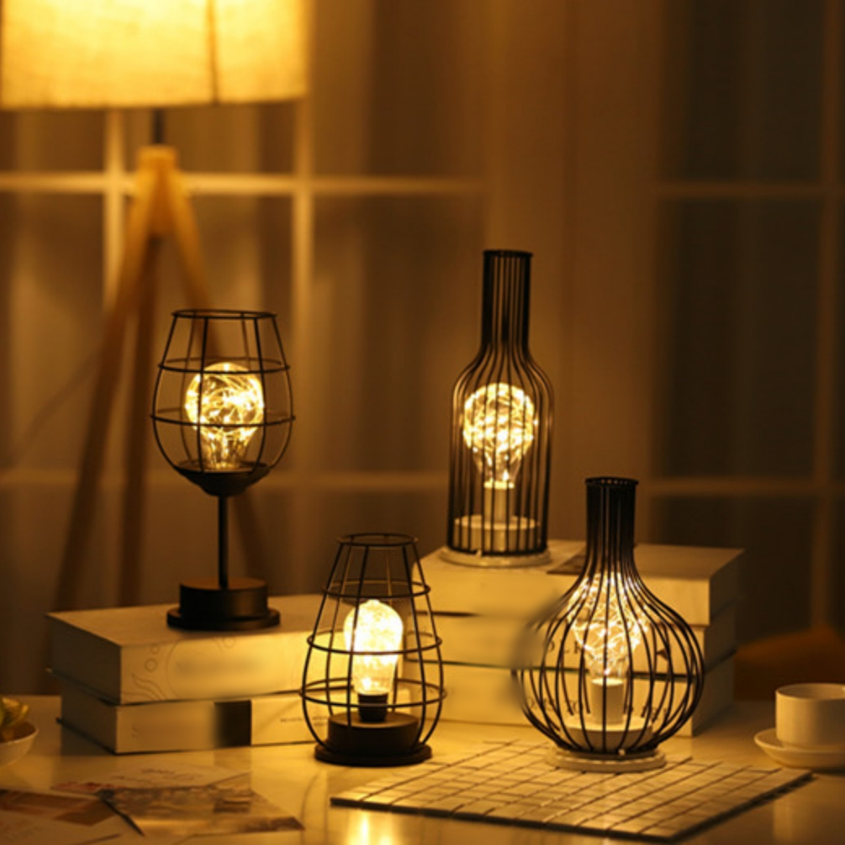 Vier dekorative Lampen in Form von Weingläsern und Flaschen mit leuchtenden Lichtern im Inneren.