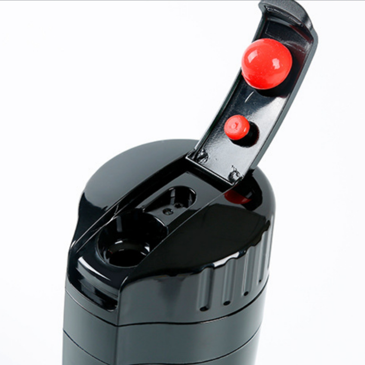 Schwarze Wasserflasche mit rotem Deckel. Der Deckel ist geöffnet und zeigt zwei rote Knöpfe.