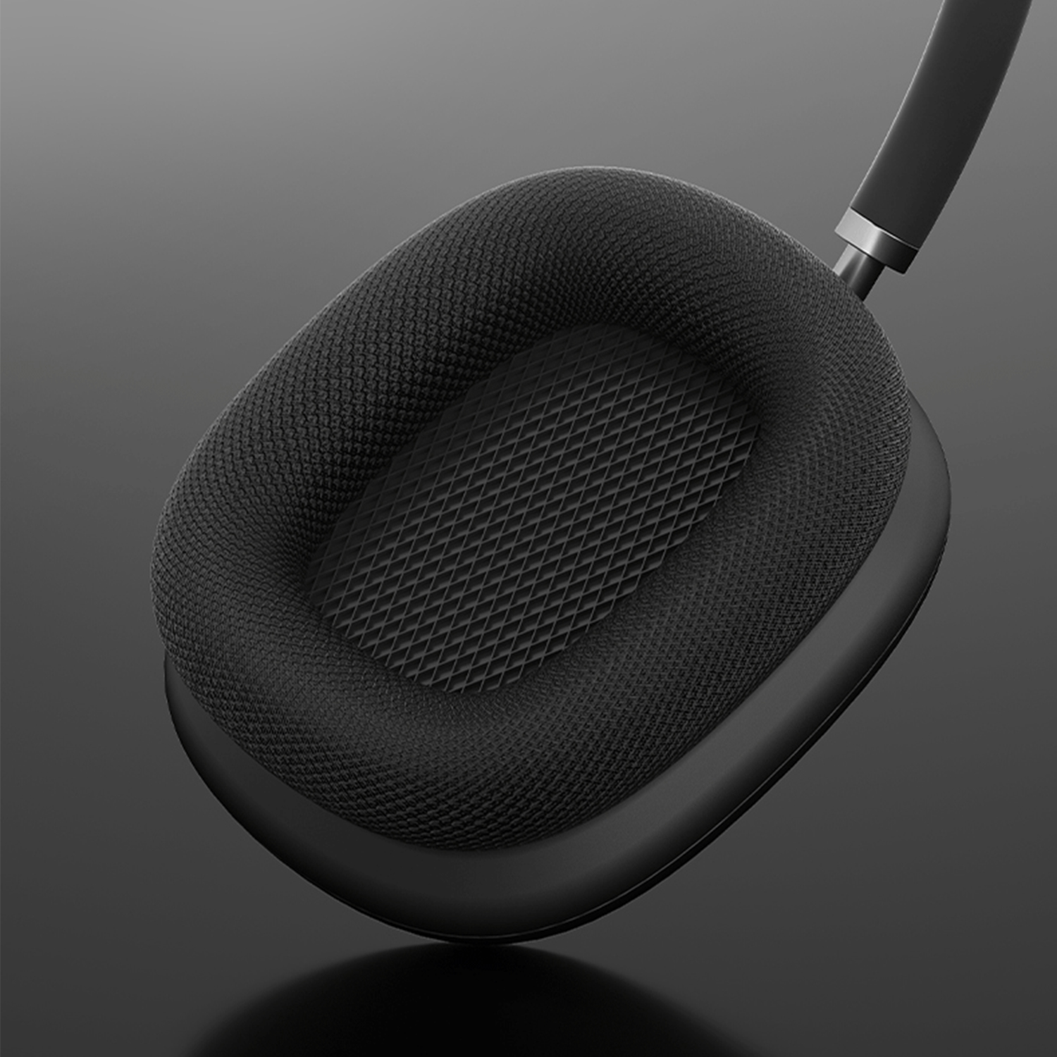 Ein schwarzes Over-Ear-Kopfhörerkissen mit strukturierter Oberfläche ist vor einem dunkelgrauen Hintergrund isoliert.