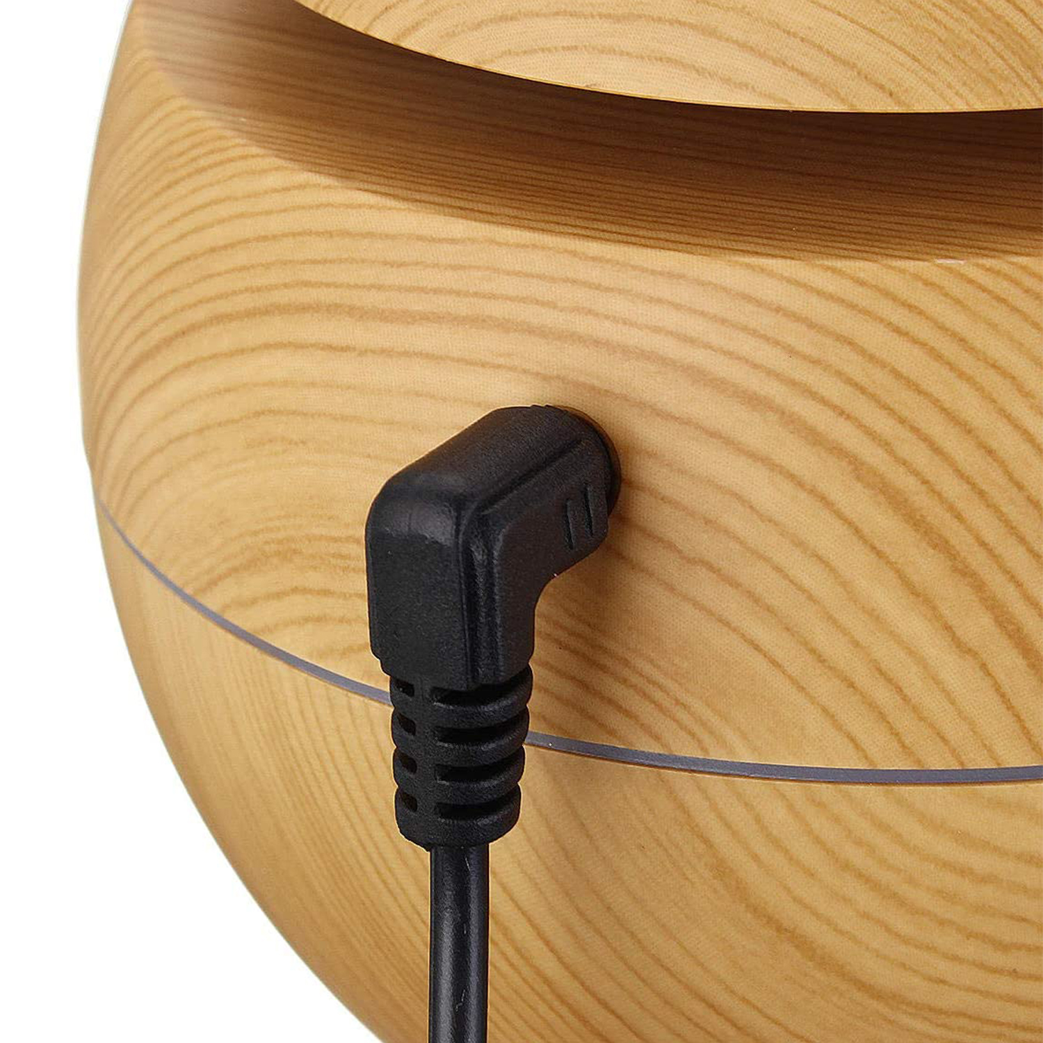 Difusor de madera con adaptador de corriente negro enchufado. Primer plano. Grano de madera claro.