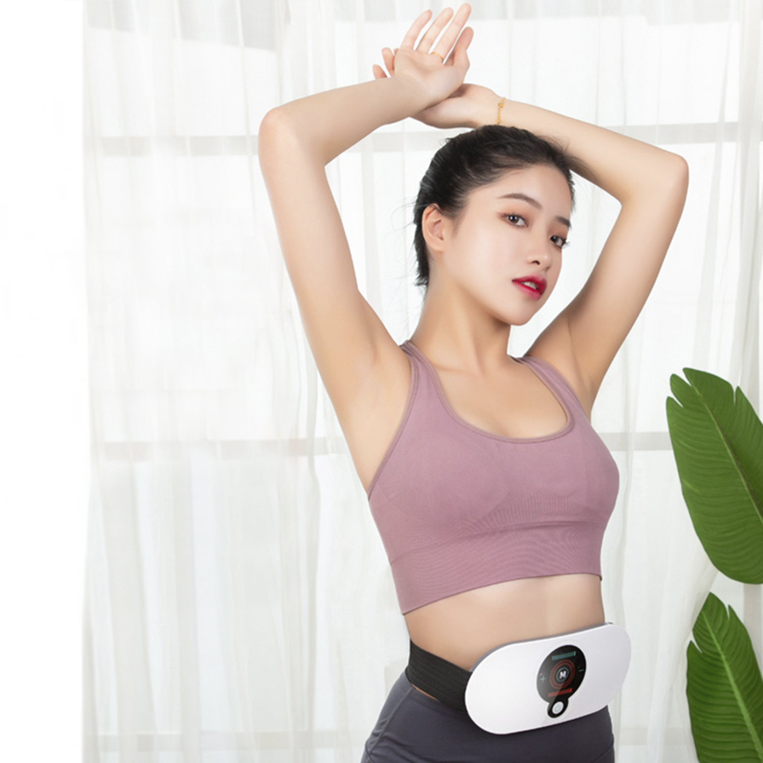 Mujer con ropa deportiva y cinturón negro. Brazos arriba, fondo cortina y planta.