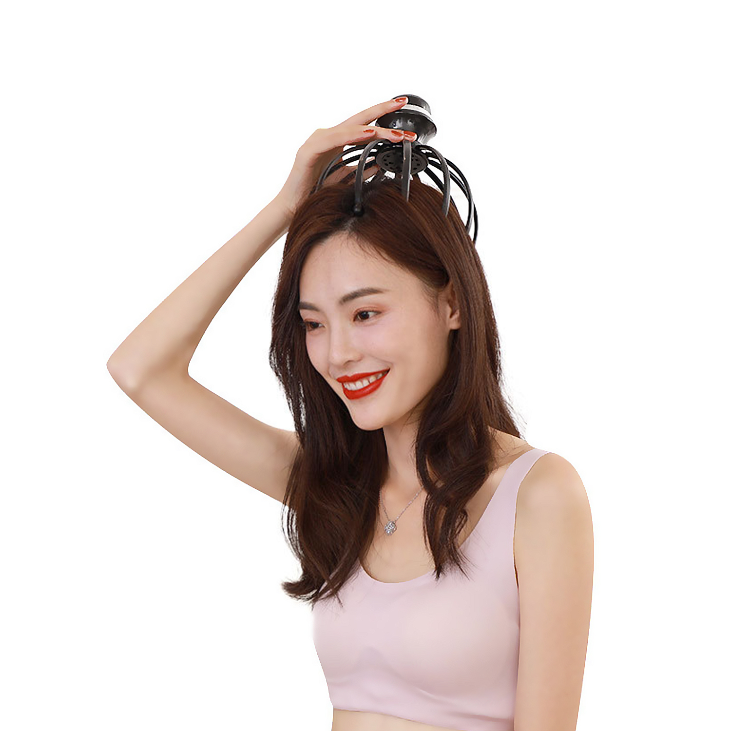 Una donna sorride usando un massaggiatore per la testa nero. Indossa un top rosa.