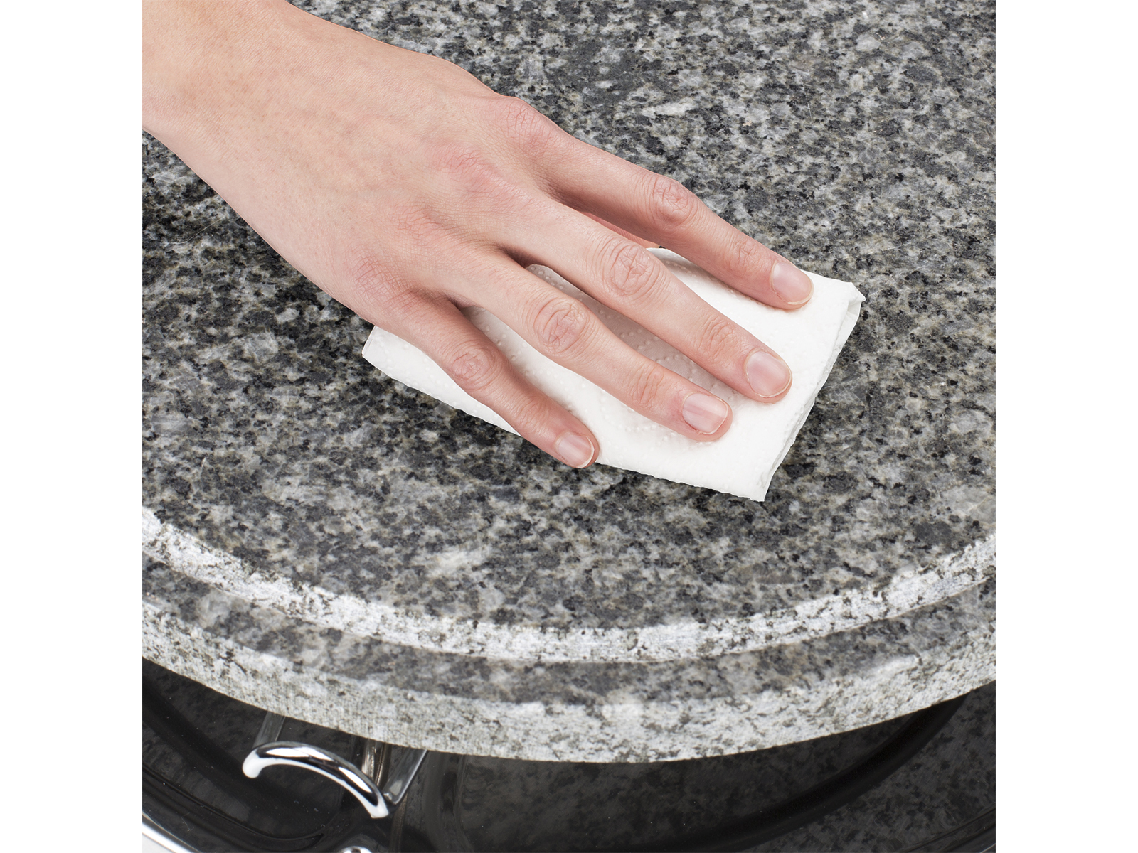 Hand wischt eine Granit-Arbeitsplatte mit einem weißen Tuch ab. Granit-Arbeitsplatte rund.