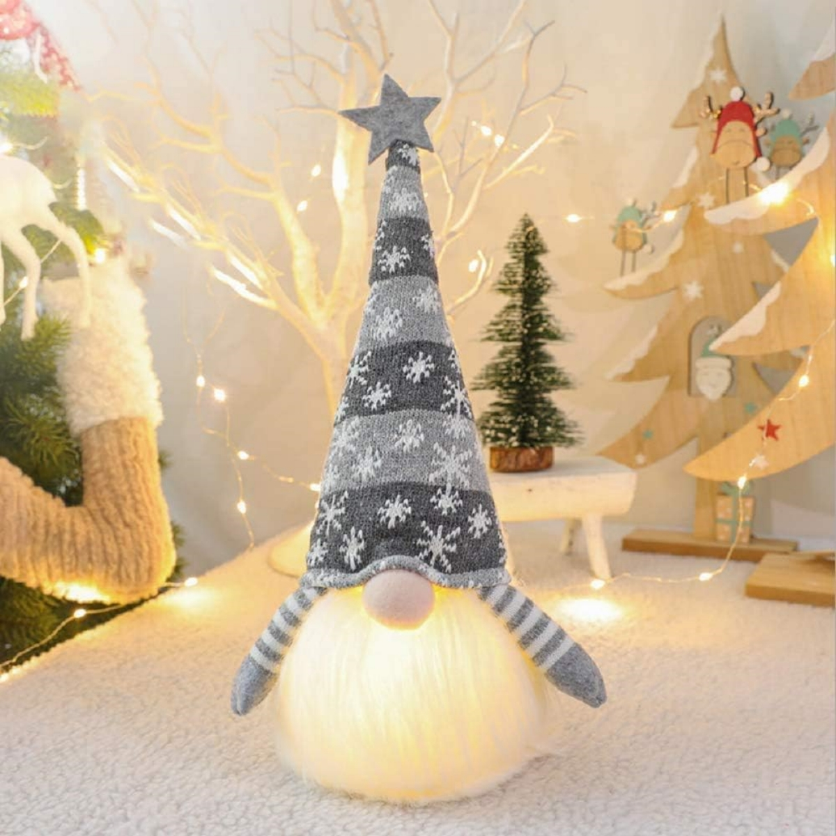 Weihnachtszwerg-Figur mit Sternhut, auf einem Tisch mit Weihnachtsdekorationen.