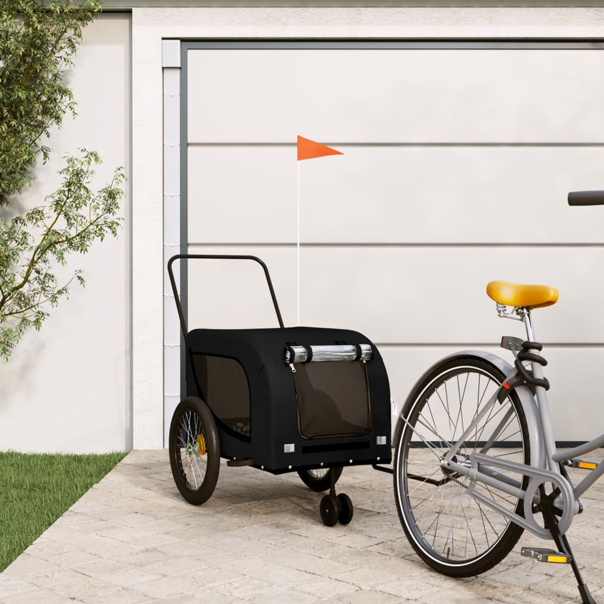 Schwarzer Haustieranhänger an einem Fahrrad. Orangefarbene Fahne. Weißes Garagentor im Hintergrund.
