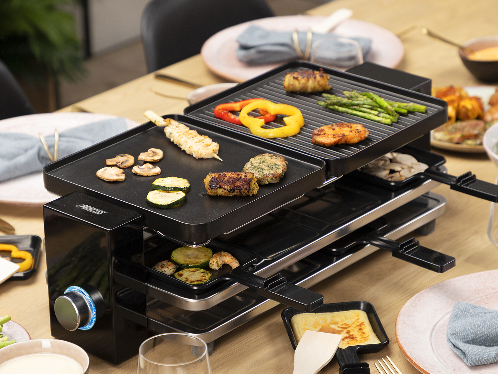 Ein Raclette-Grill mit verschiedenen Lebensmitteln, bereit zum Grillen.