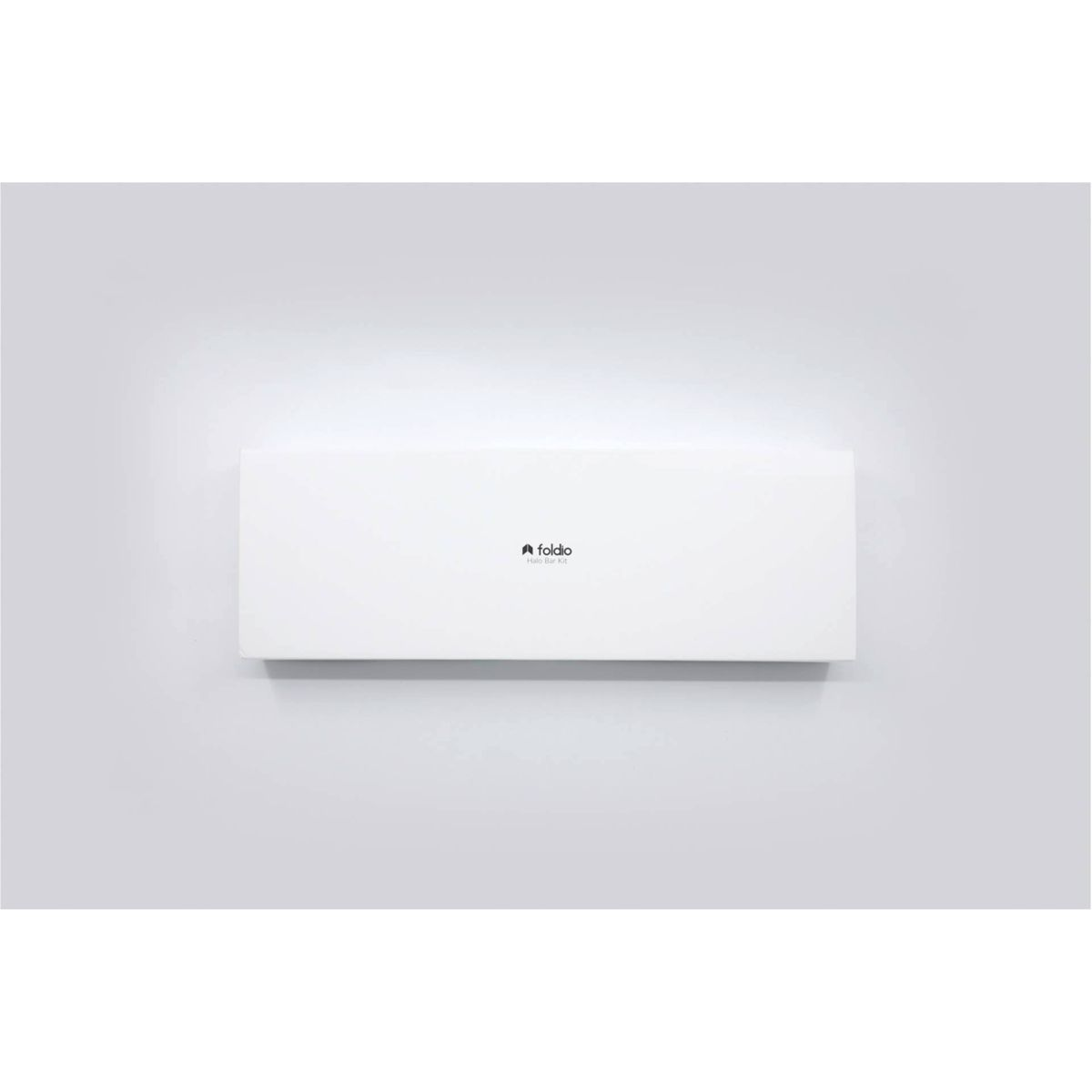 Objeto rectangular blanco con un logotipo, probablemente un acondicionador de aire, montado en una pared blanca.