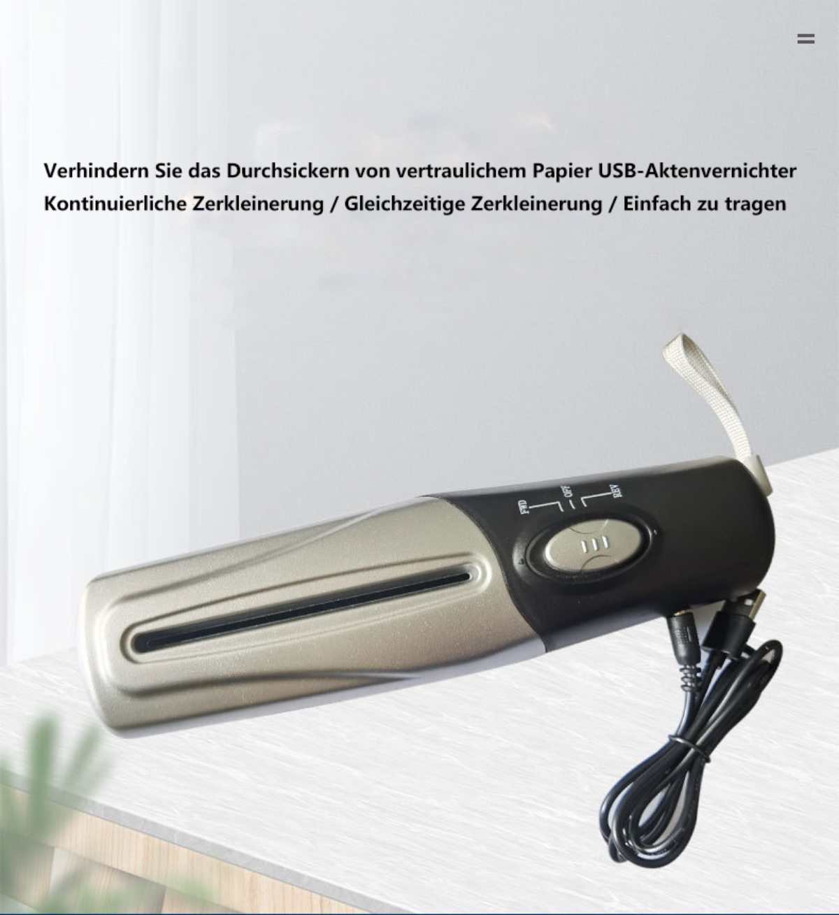 Silber-schwarzer USB-Aktenvernichter mit Kabeln auf hellbrauner Oberfläche.
