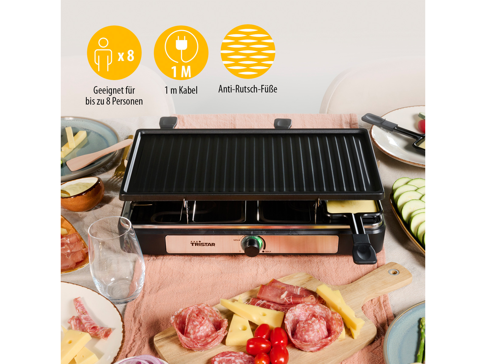Una griglia per raclette con formaggio, salame, verdure e piatti su un tavolo di legno.