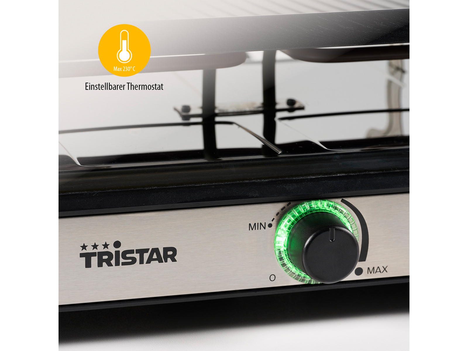 Primo piano di una griglia per raclette Tristar. Comandi ed elemento riscaldante visibili. Luce verde sulla manopola.