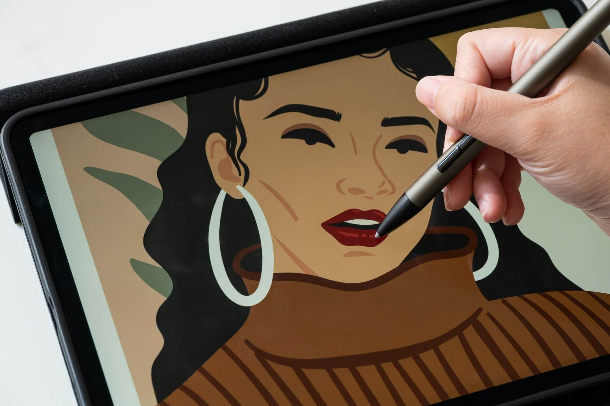 Una mano disegna su un tablet con una penna. Lo schermo mostra un ritratto di donna.