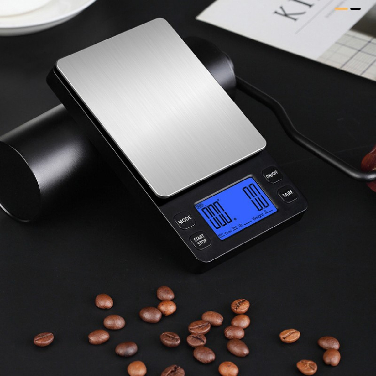 Digitale Küchenwaage mit Anzeige, Kaffeebohnen und Löffel.