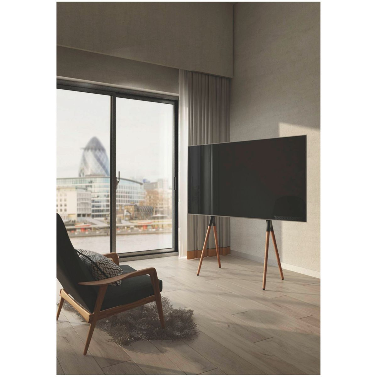 Ein Wohnzimmer mit großem Fernseher auf einem Holzständer. Ein Stuhl und Fenster im Hintergrund.