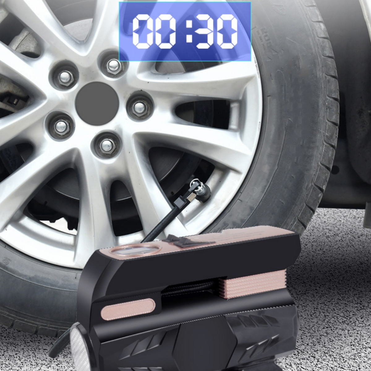 Reifenfüller neben einem Autoreifen. Der Timer zeigt 00:30 an. Das Gerät ist schwarz und roségold.
