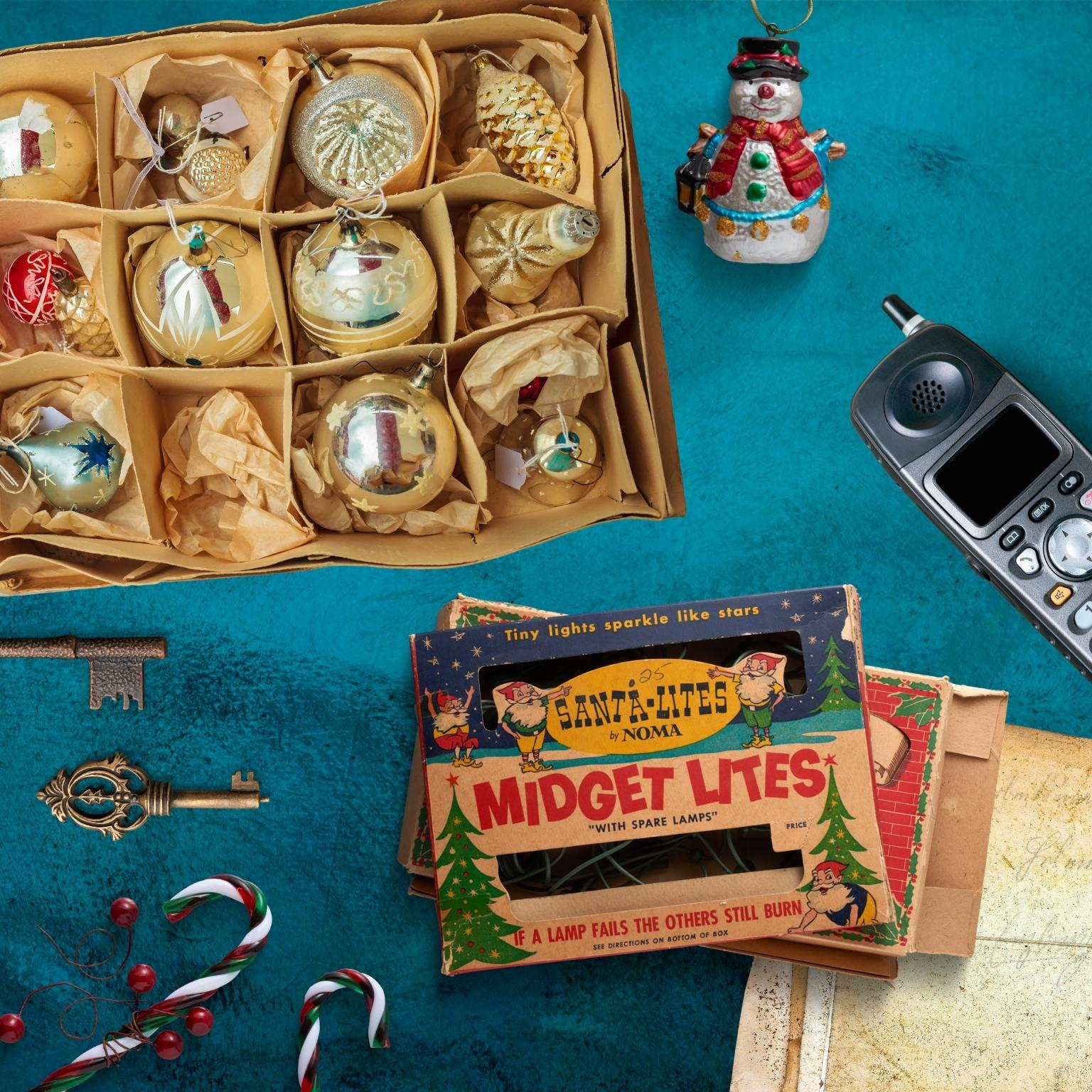 Weihnachtsschmuck und -dekorationen in einer Box, mit einem Schneemann und einem Vintage-Telefon.