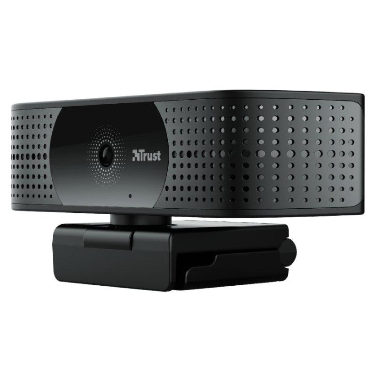 Webcam negra con logo Trust. Tiene forma rectangular con agujeros y un soporte.