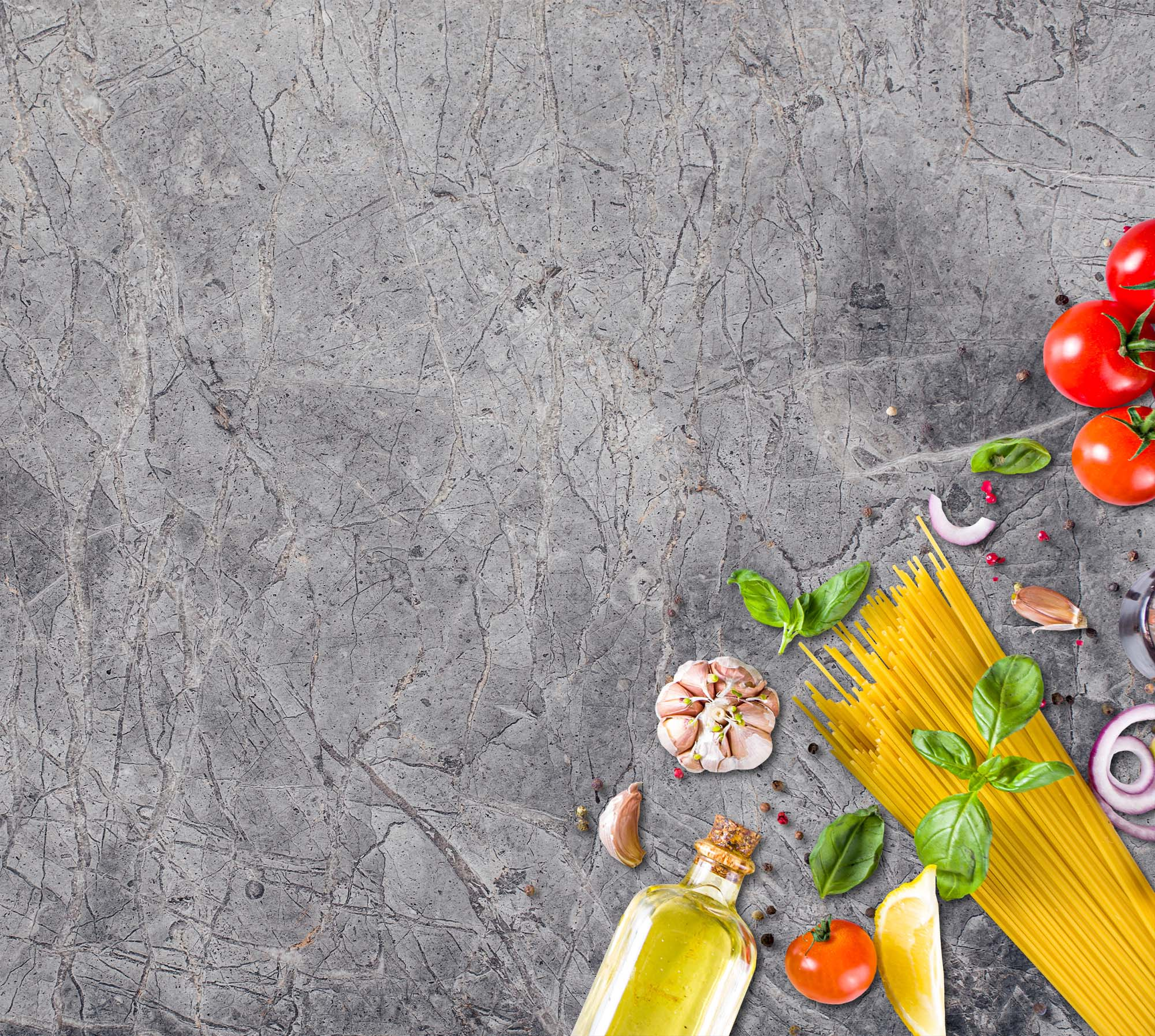 Draufsicht auf Zutaten auf einer grauen Marmoroberfläche: Tomaten, Pasta, Öl, Knoblauch, Basilikum und Zwiebeln.