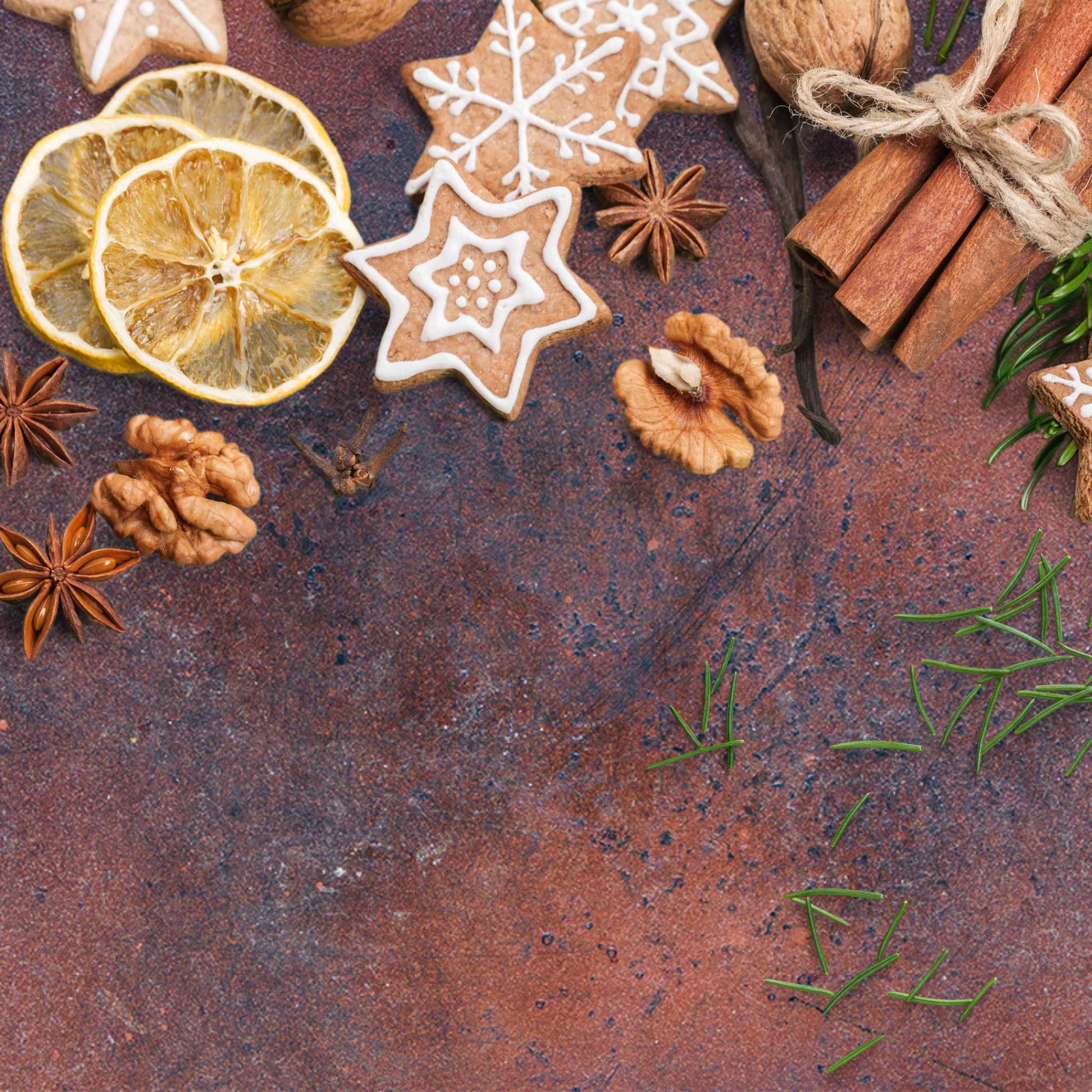 Weihnachtsplätzchen, Walnüsse, Zimt, Sternanis und getrocknete Zitronenscheiben auf rustikaler Oberfläche.