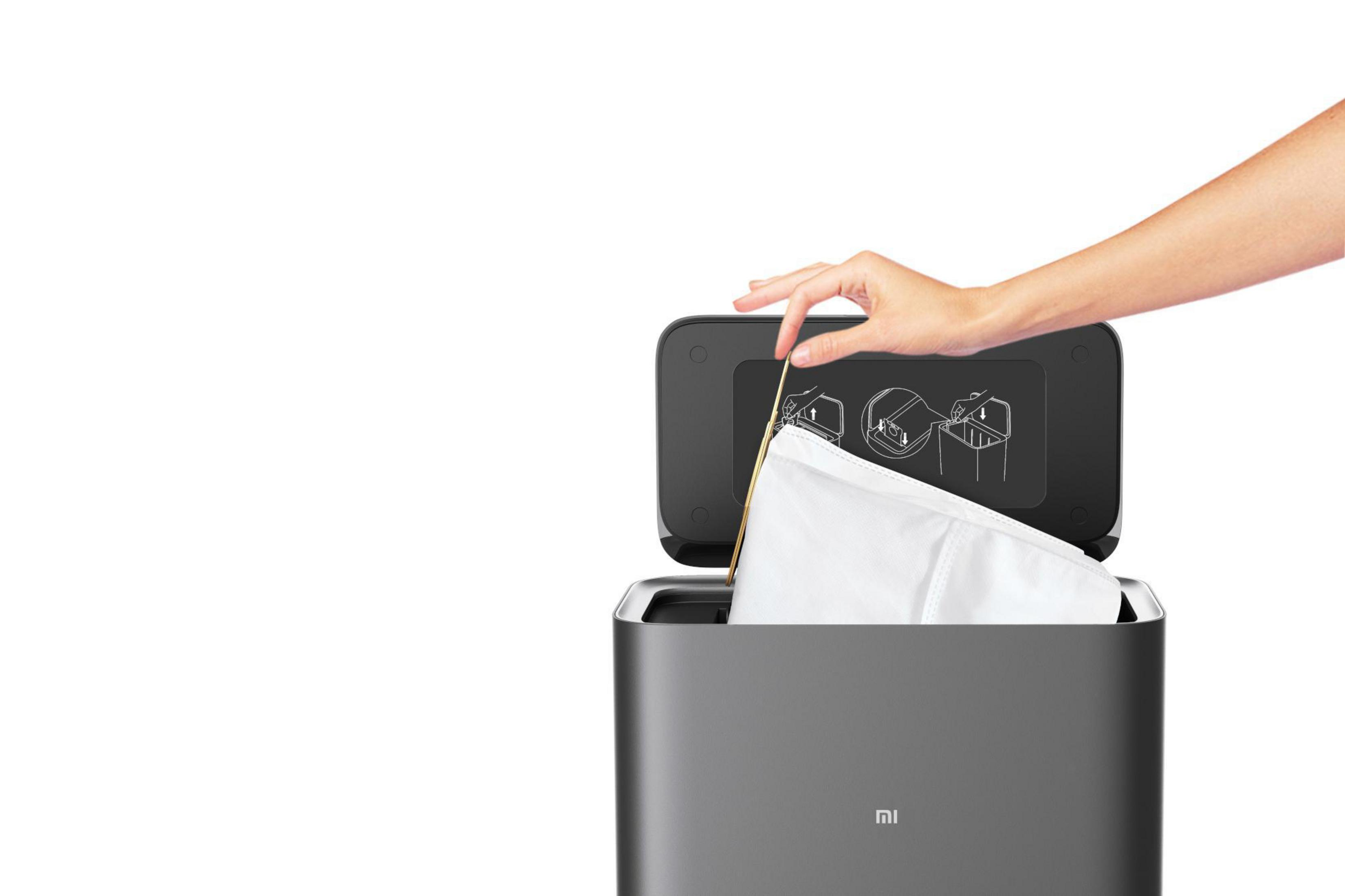 Hand legt einen neuen Filterbeutel in einen schwarzen Roboterstaubsauger ein.